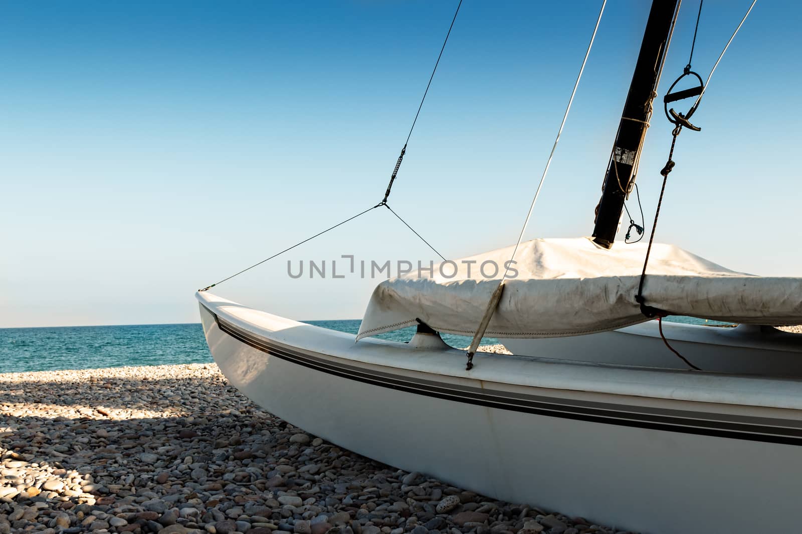 Catamaran on the beach on the stones. Horizontal image.