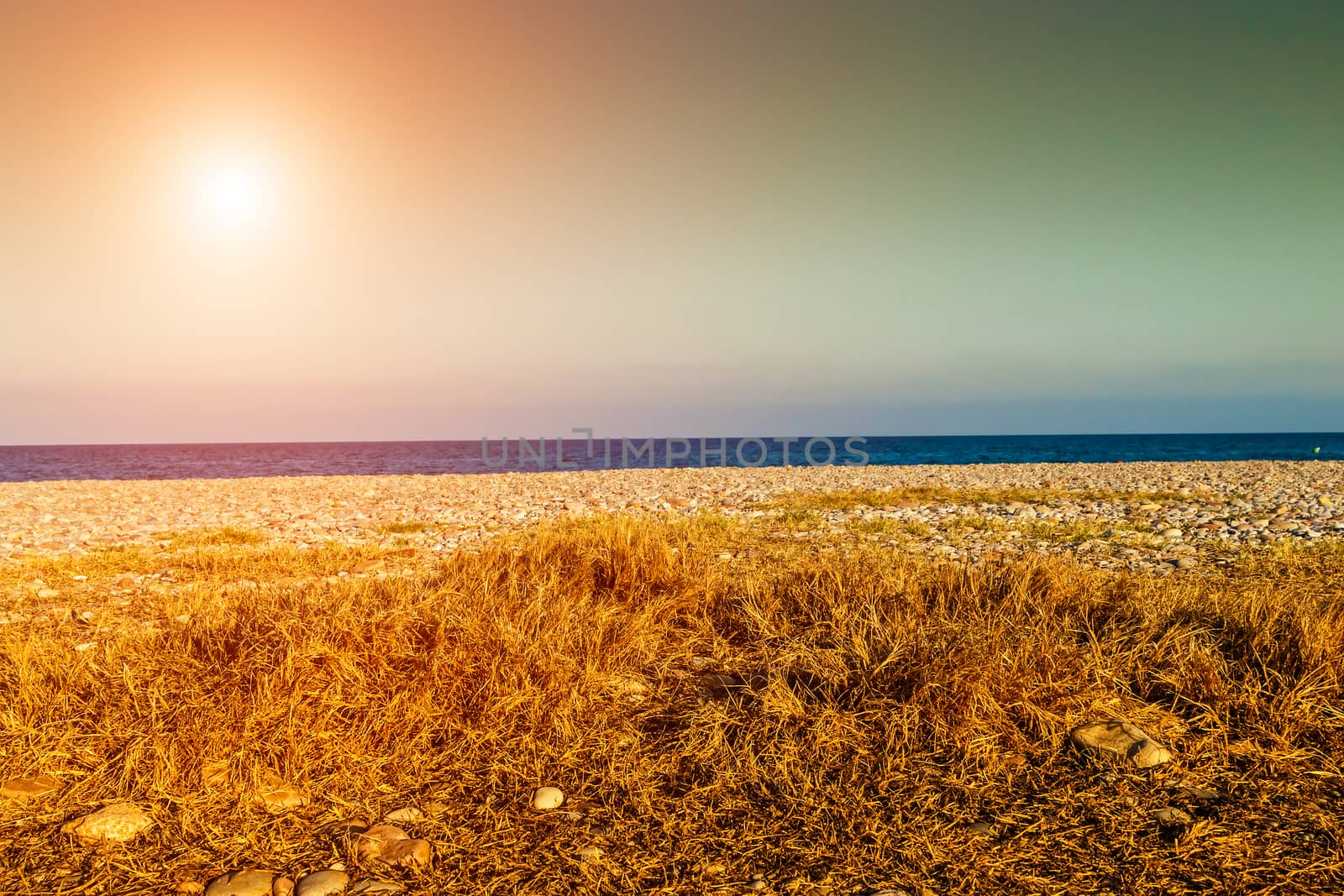 Sunset on the beach with the sea in the background. Horizontal image.