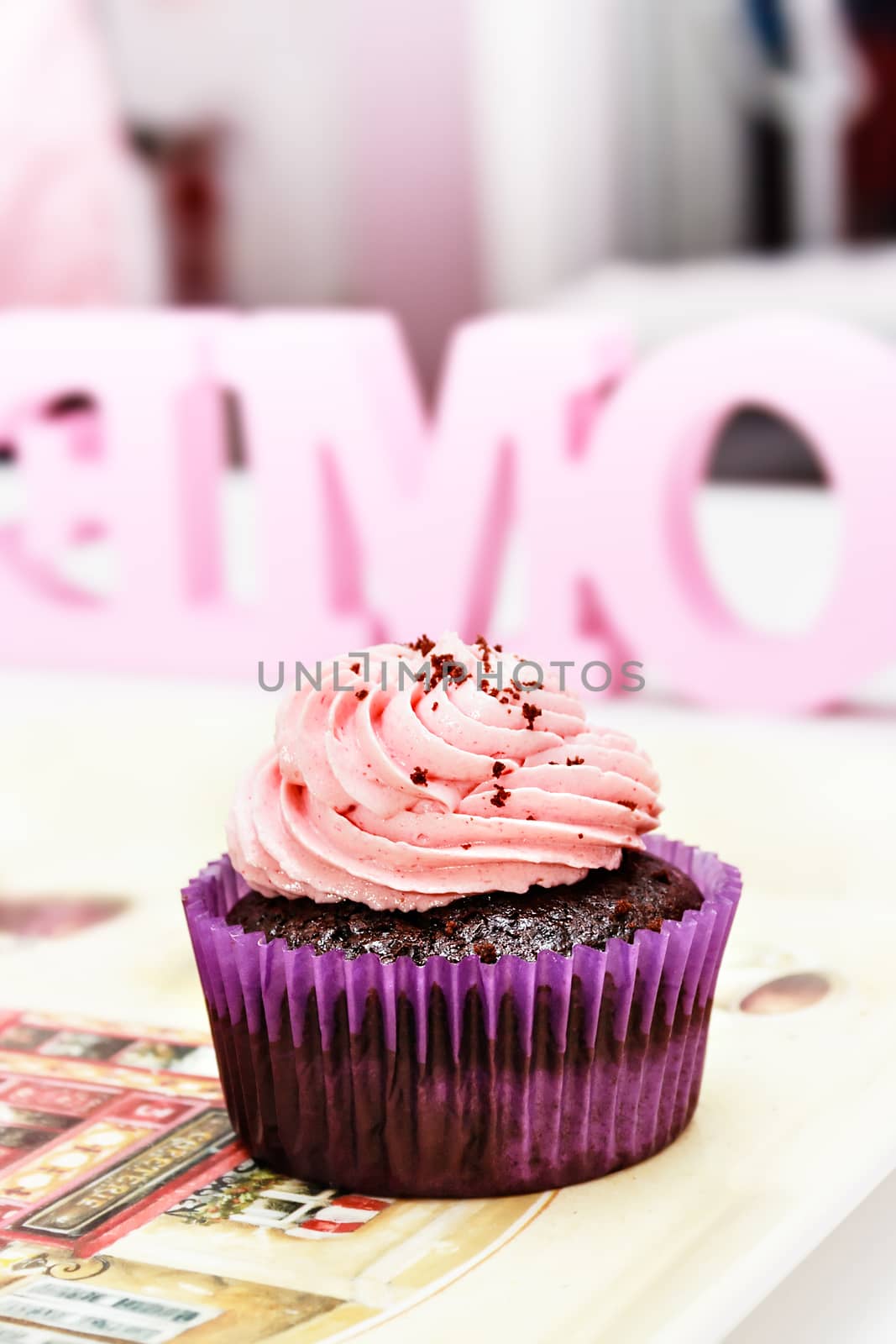 Chocolate and strawberry cream cupcake on a professional bakery. Vertical image.