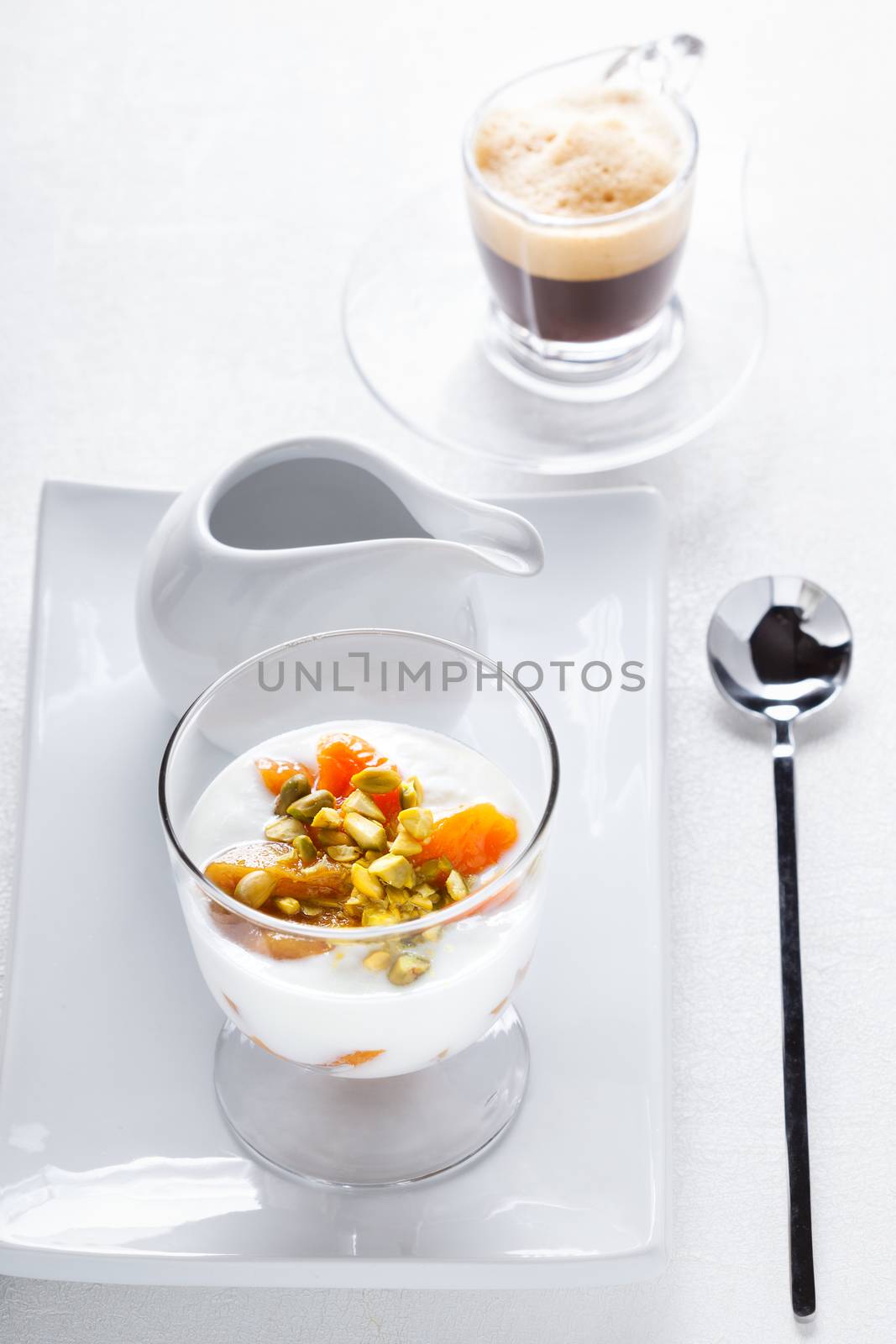 Yogurt with dried apricots and coffee on a table