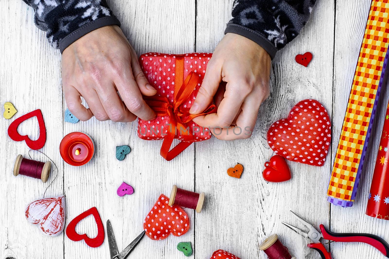 Packing holiday gifts for Valentine's day.Thread,button and symbolic heart.
