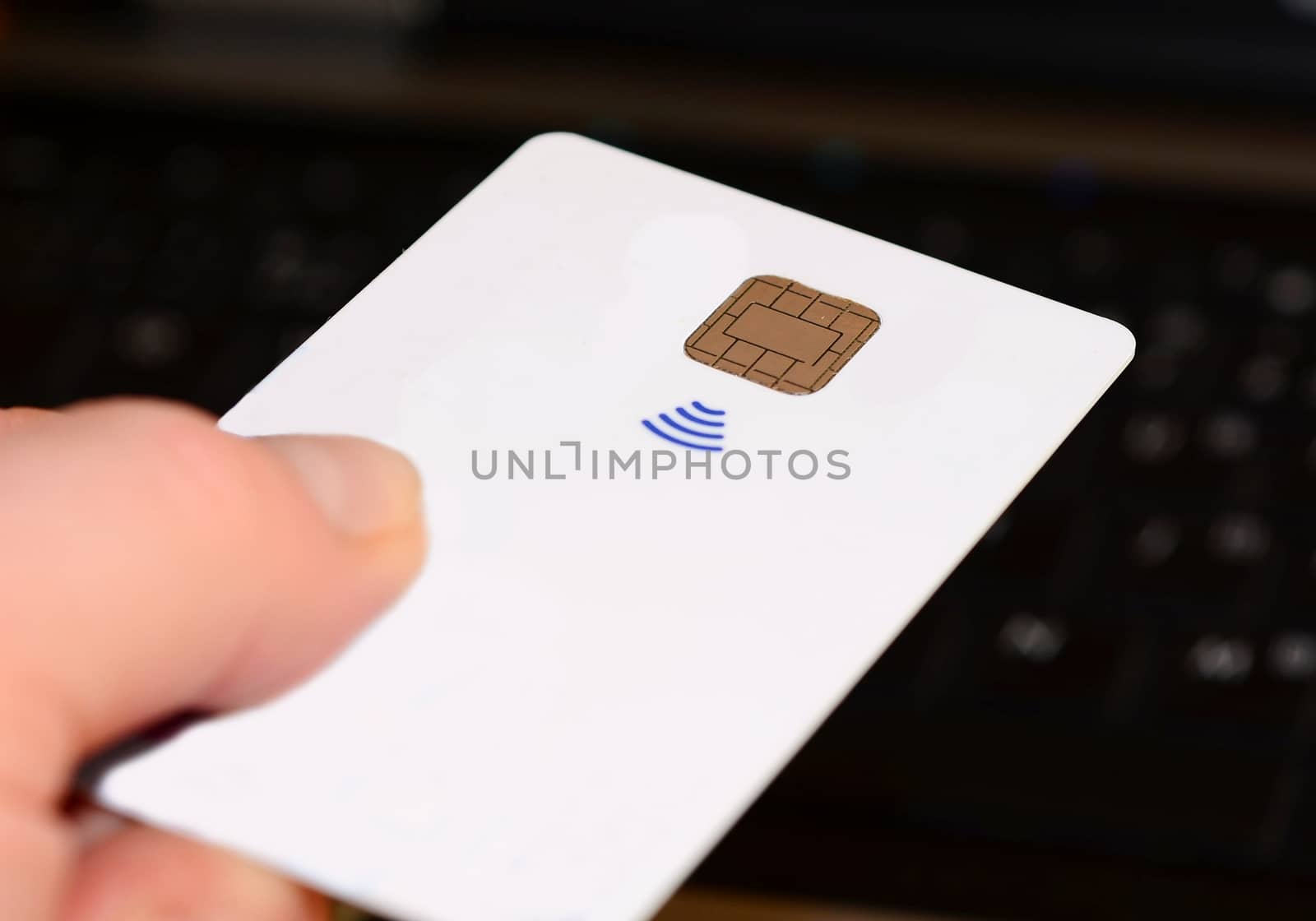 Hand holding and paying with a all white contactless credit card.