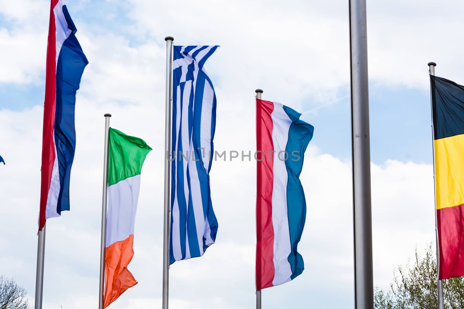 Several Europe countries flags arranged in front of a blue sky.