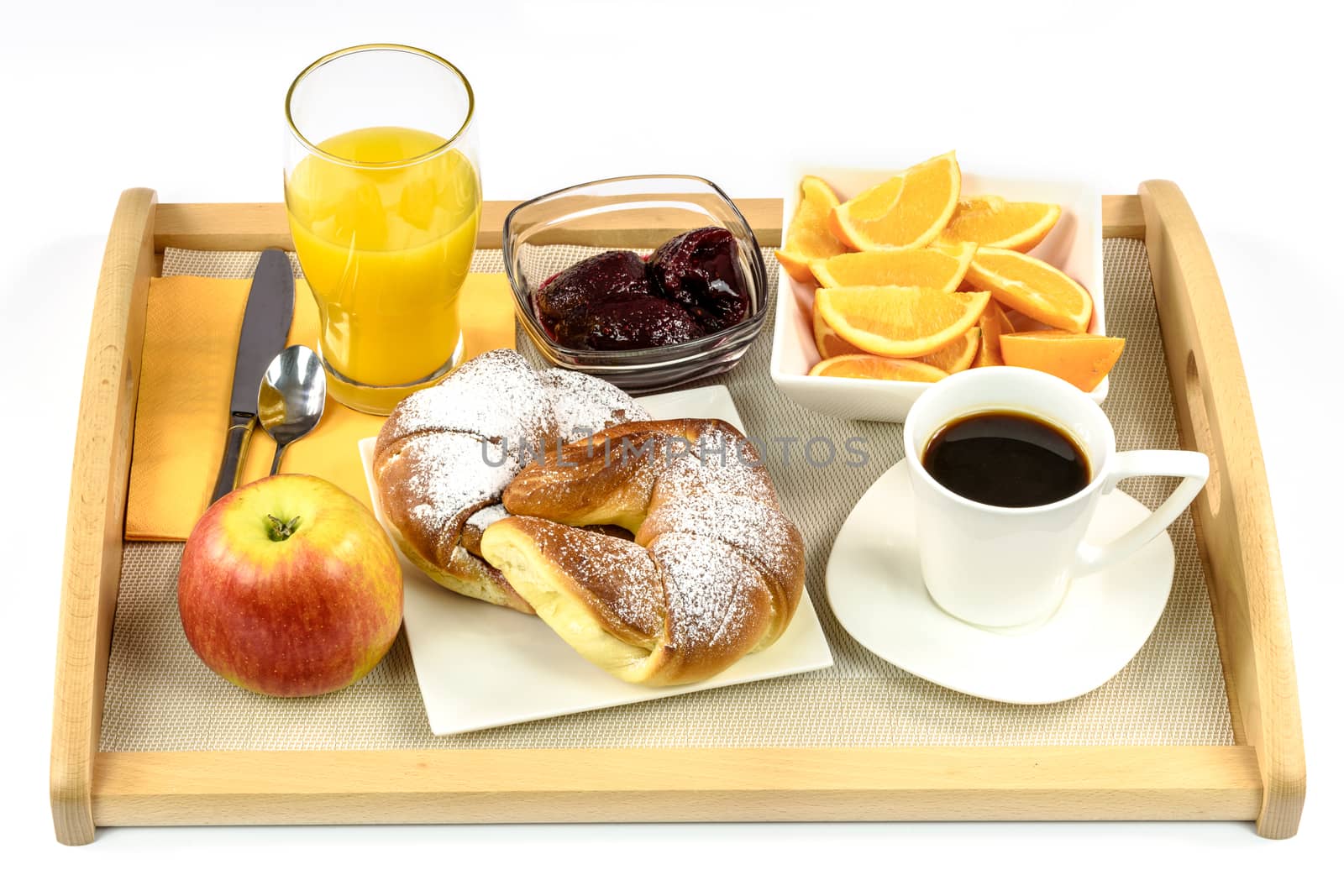 Overhead shot on hotel's breakfast tray with croissants, coffee, oranges, juice, jam, apple and cutlery