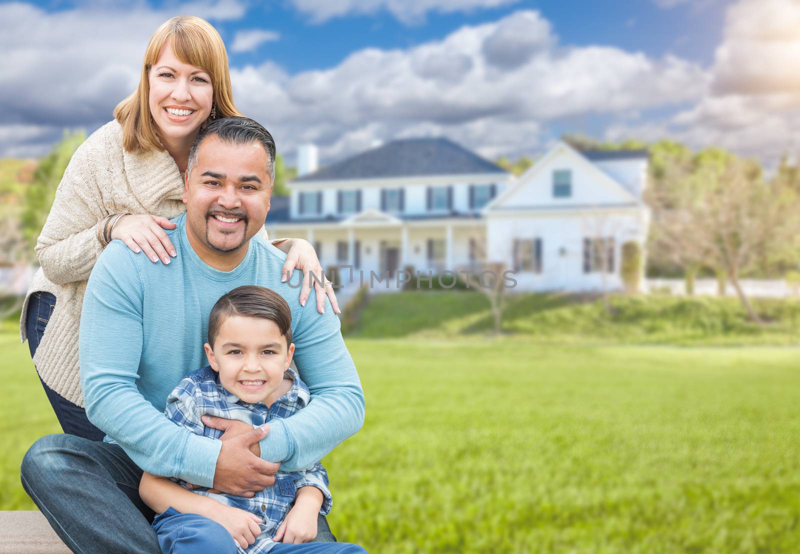 Happy Mixed Race Hispanic and Caucasian Family Portrait In Front of House.