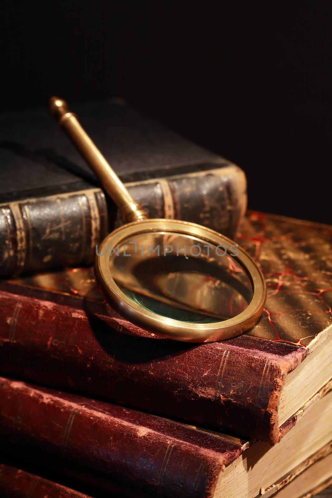 Vintage library. Closeup of magnifying glass on old book