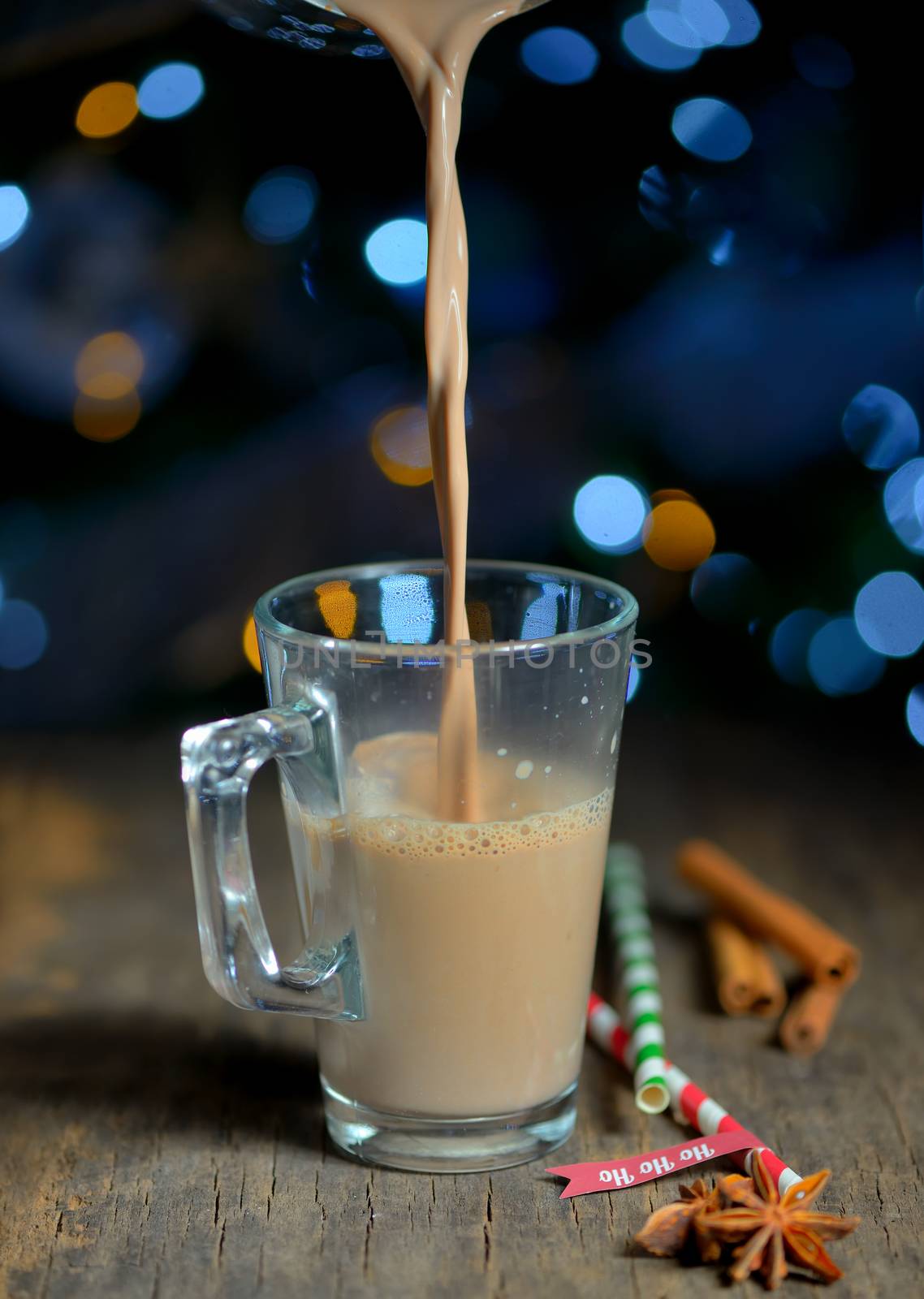 Cup of hot cocoa beverage and Christmas tree lights