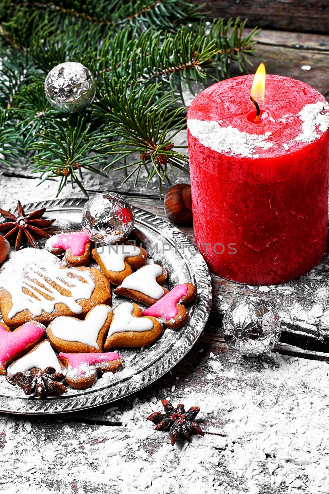 Homemade Christmas cookies in the shape of hearts and red candle