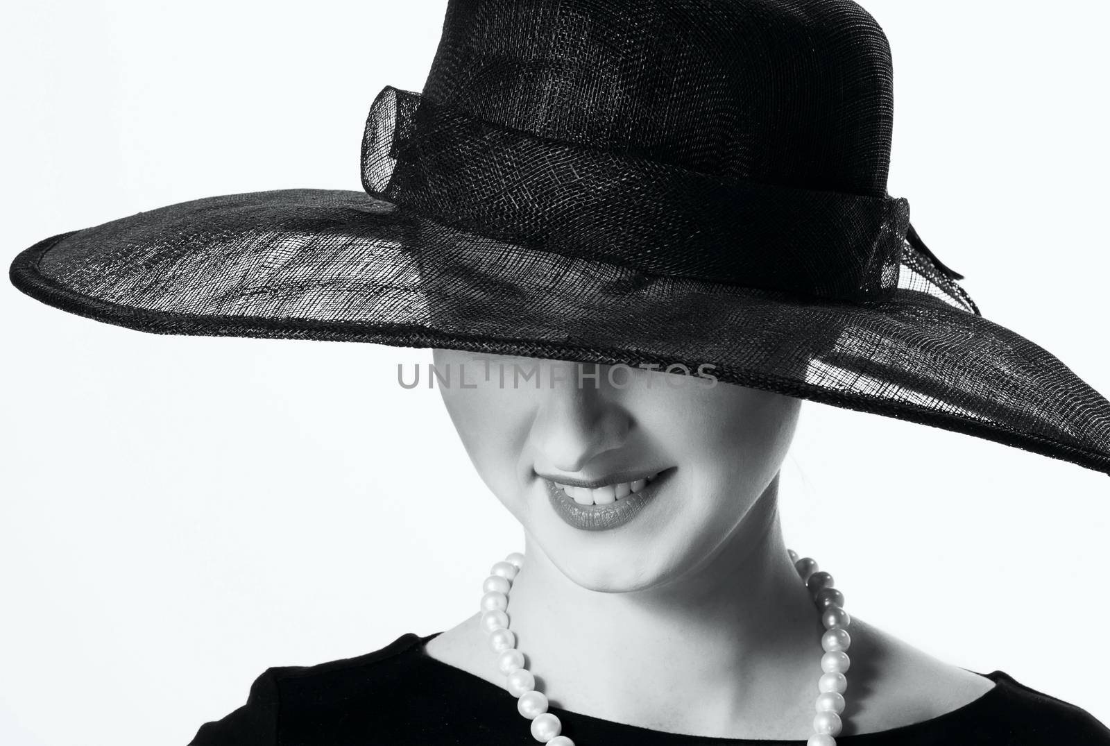 Close-up portrait of a beautiful woman in a black hat in retro style on a white background