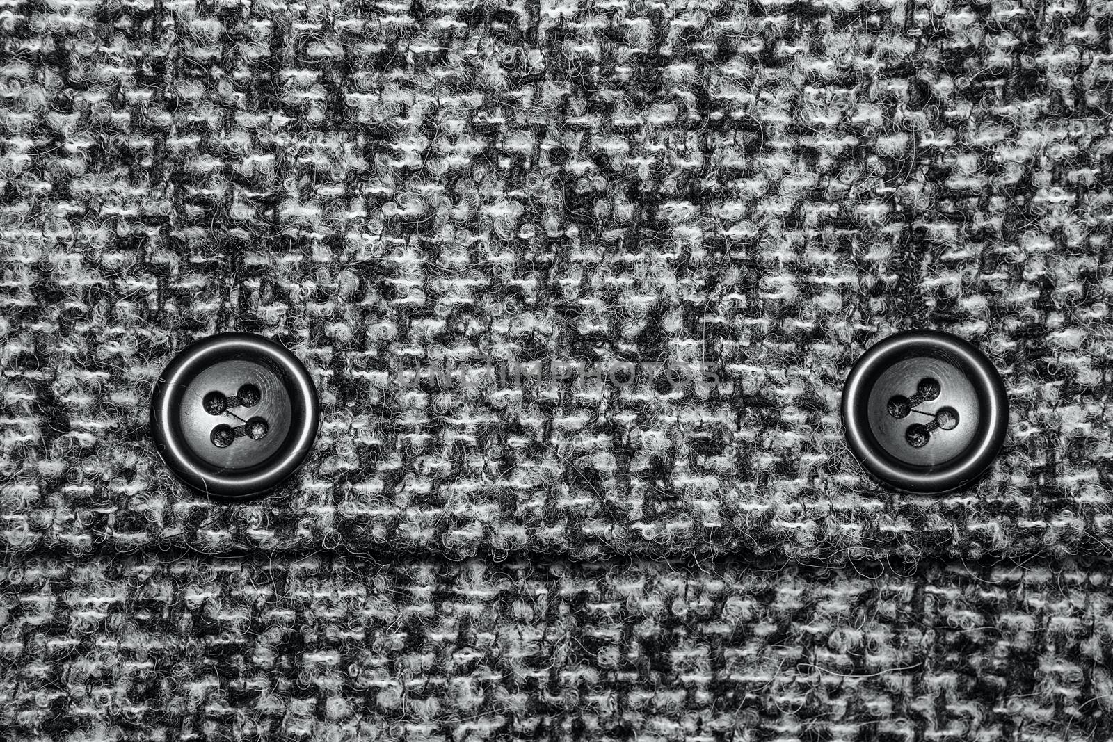 Varicolored tweed like texture, varicolored wool pattern, textured melange upholstery fabric background copy space. Background texture of twill with two big black buttons