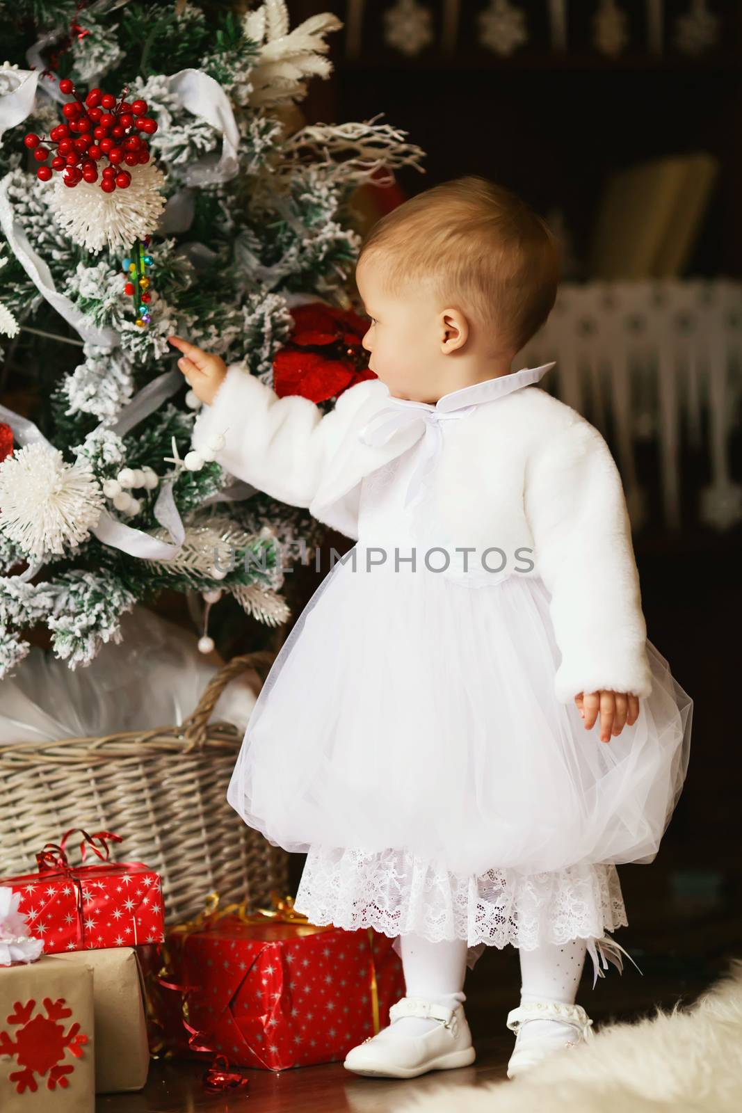 Little baby girl decorates a Christmas tree