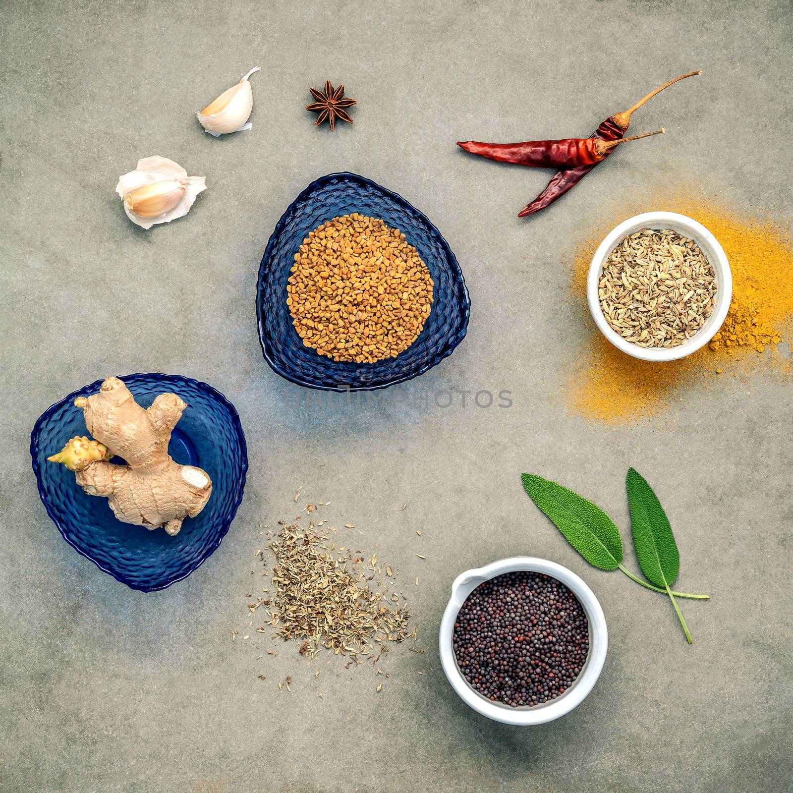 Various herbs and spices ginger,fennel seed,dried thyme ,sage leaves,garlic ,star anise ,curry powder ,chilli and fenugreek setup on concrete panel. Flat lay of spices ingredients on dark background.