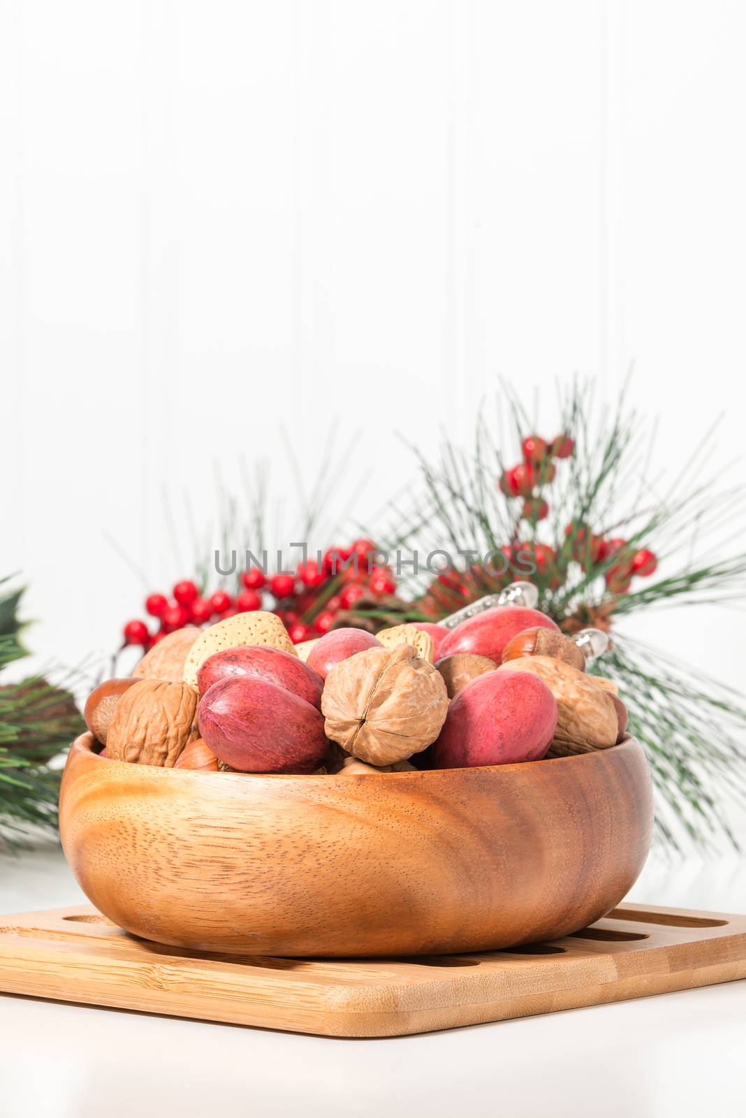 Bowl of whole mixed nuts with a seasonal background.