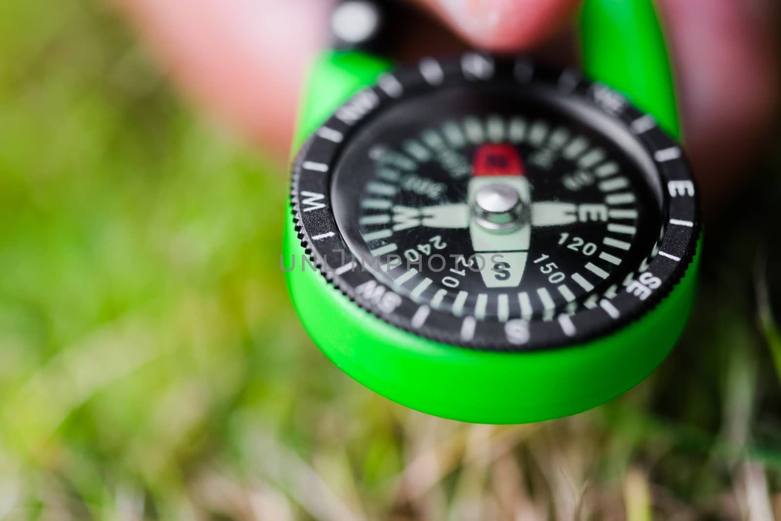 Compass held in hand pointing south direction concept