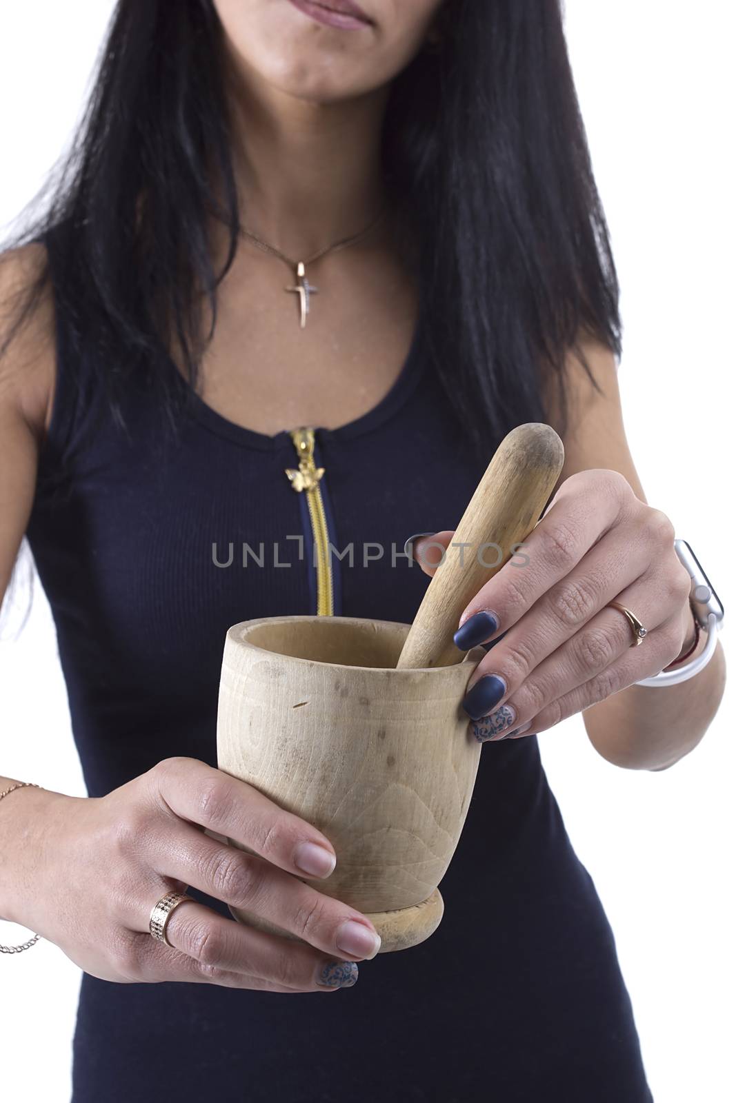 Wooden mortar in female hands on a white background