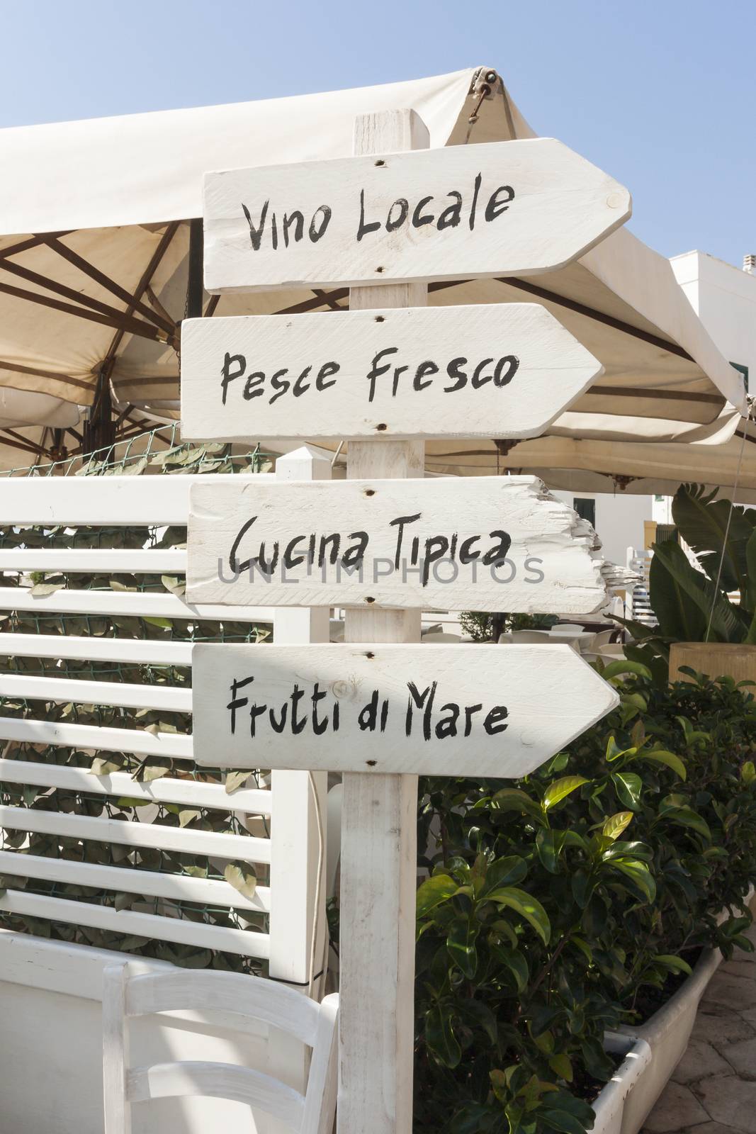 A white handmade sign indicating the restaurant and the typical local menu