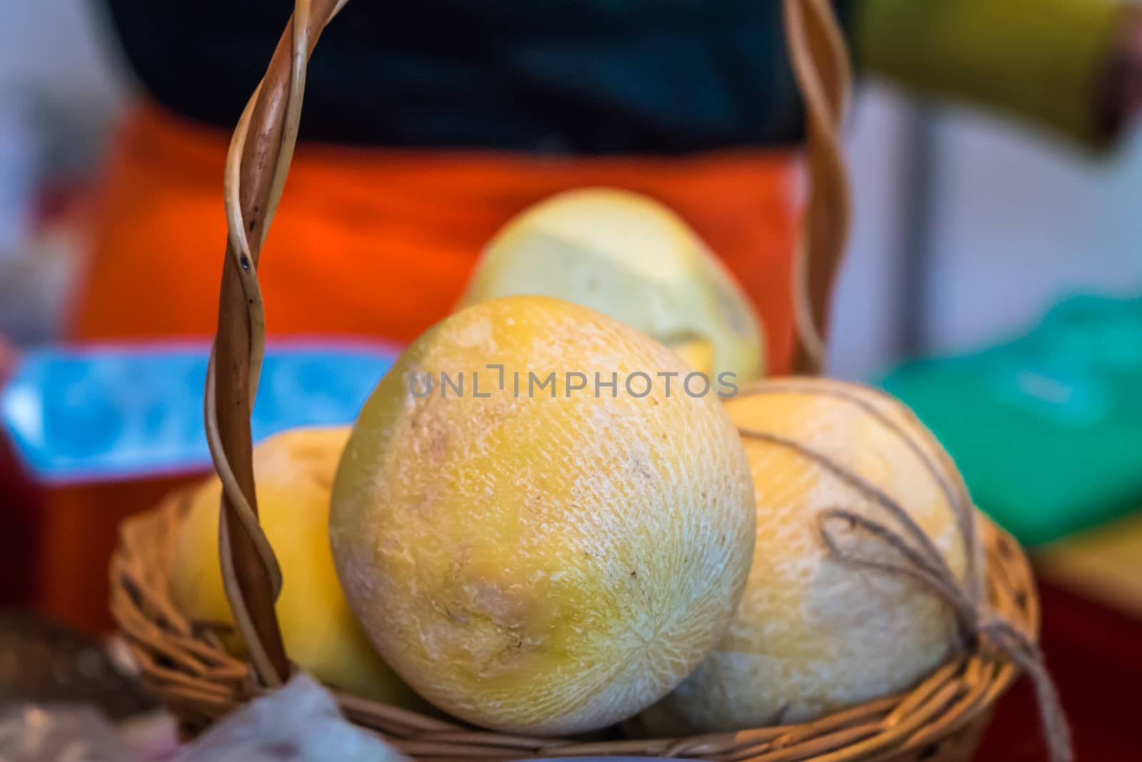 Round hard cheese in a wicker basket