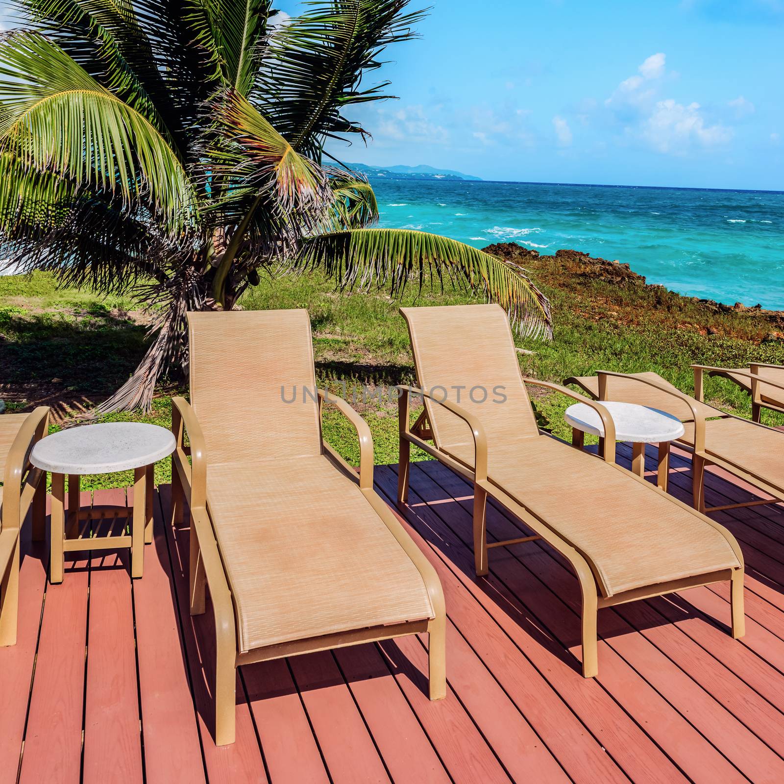 Loungers on the deck by the seafront Tobago Caribbean square composition