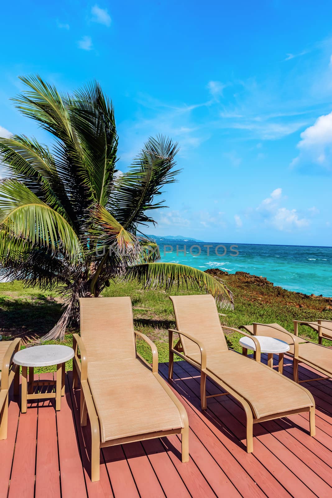 Loungers on the deck by the seafront Tobago Caribbean by Altinosmanaj