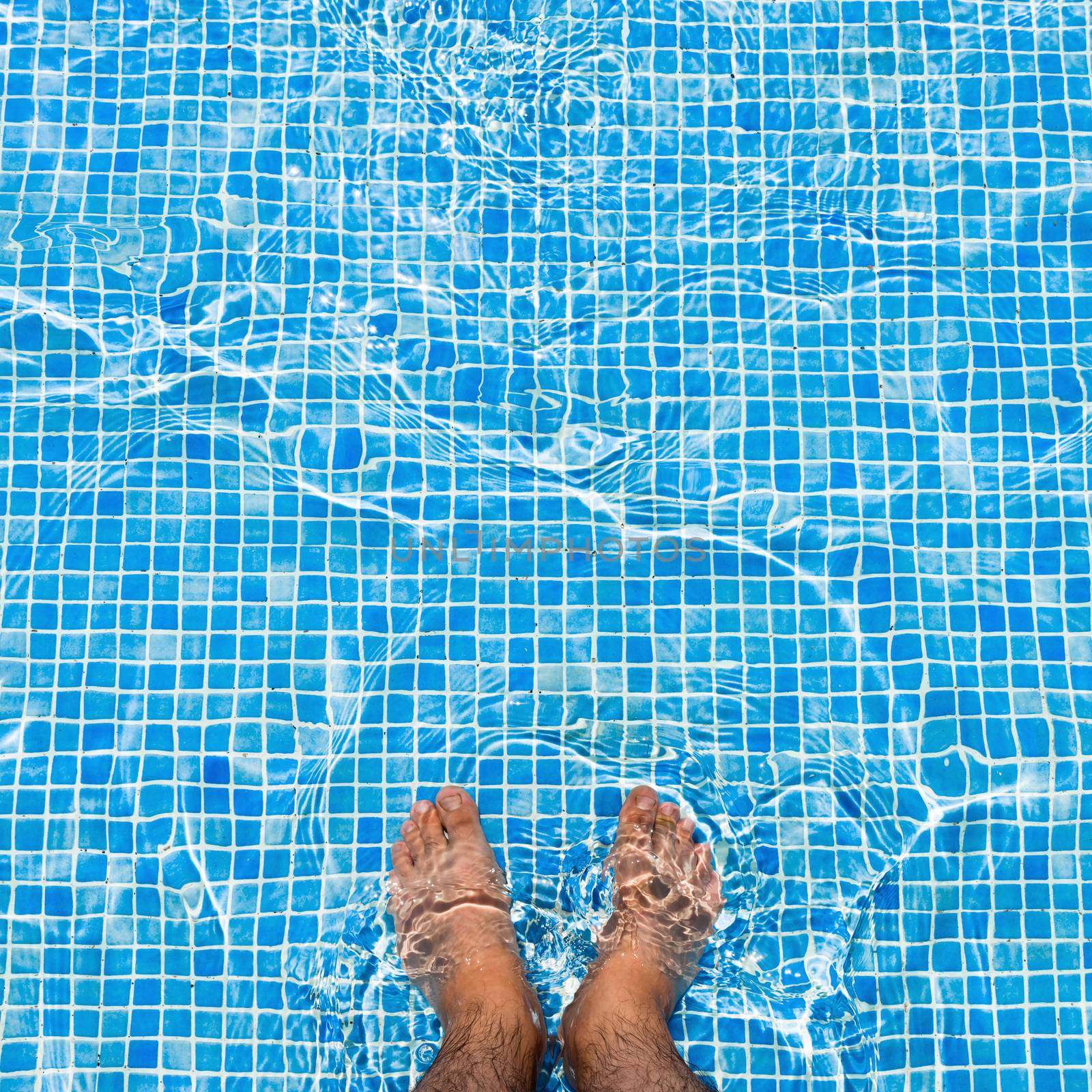 Bare feet cooling off in the pool relaxing concept - square composition by Altinosmanaj