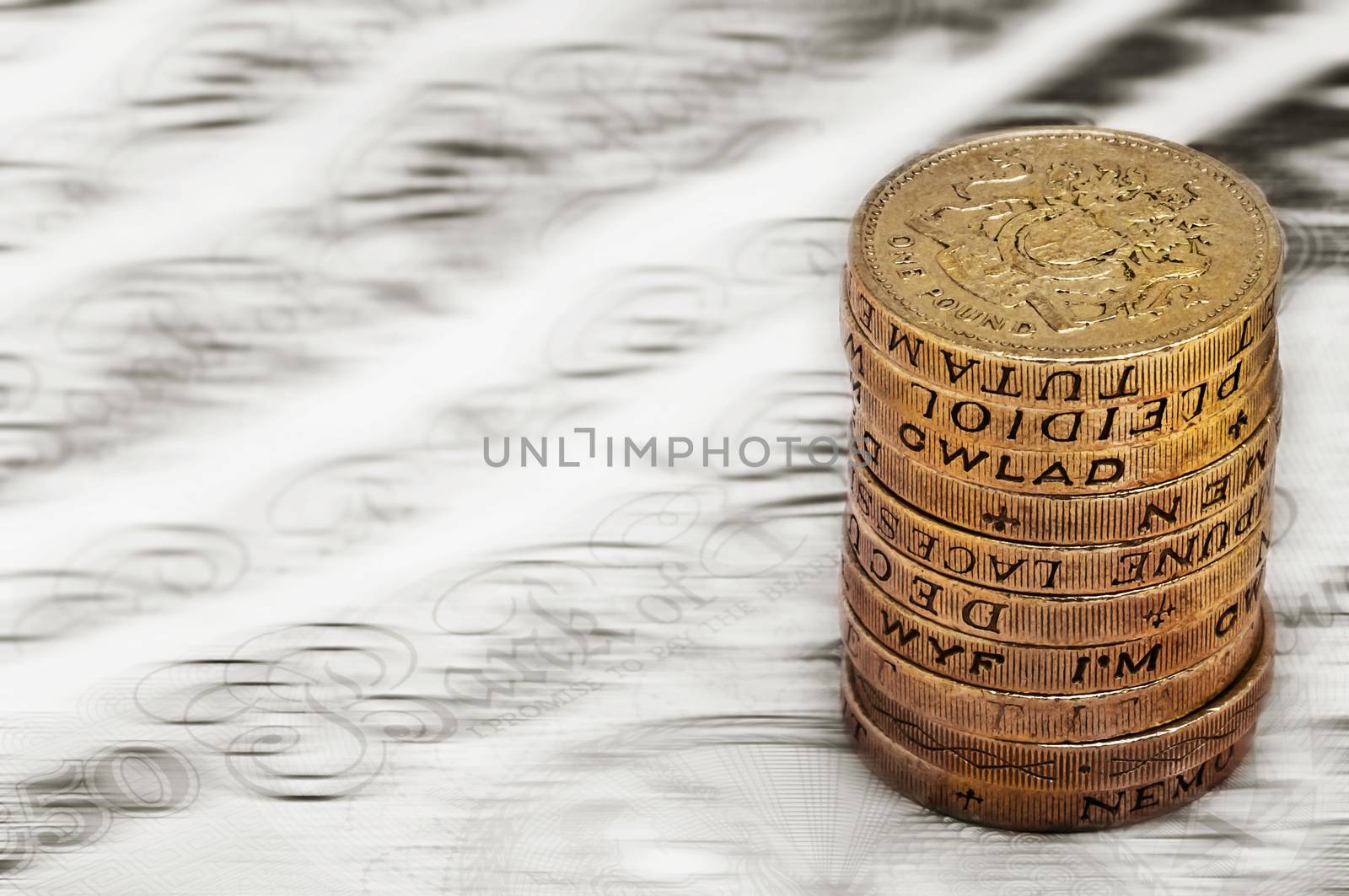 Sterling pound depreciation devaluation reduction value concept closeup macro view at UK currency stack of one pound coins by Altinosmanaj