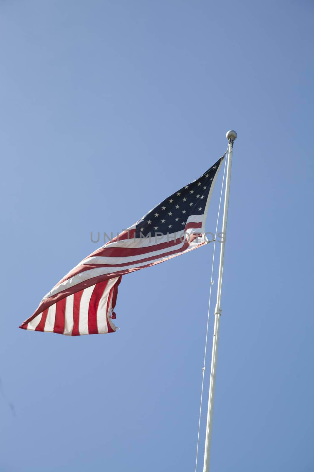 American flag flapping against a beautiful blue background
