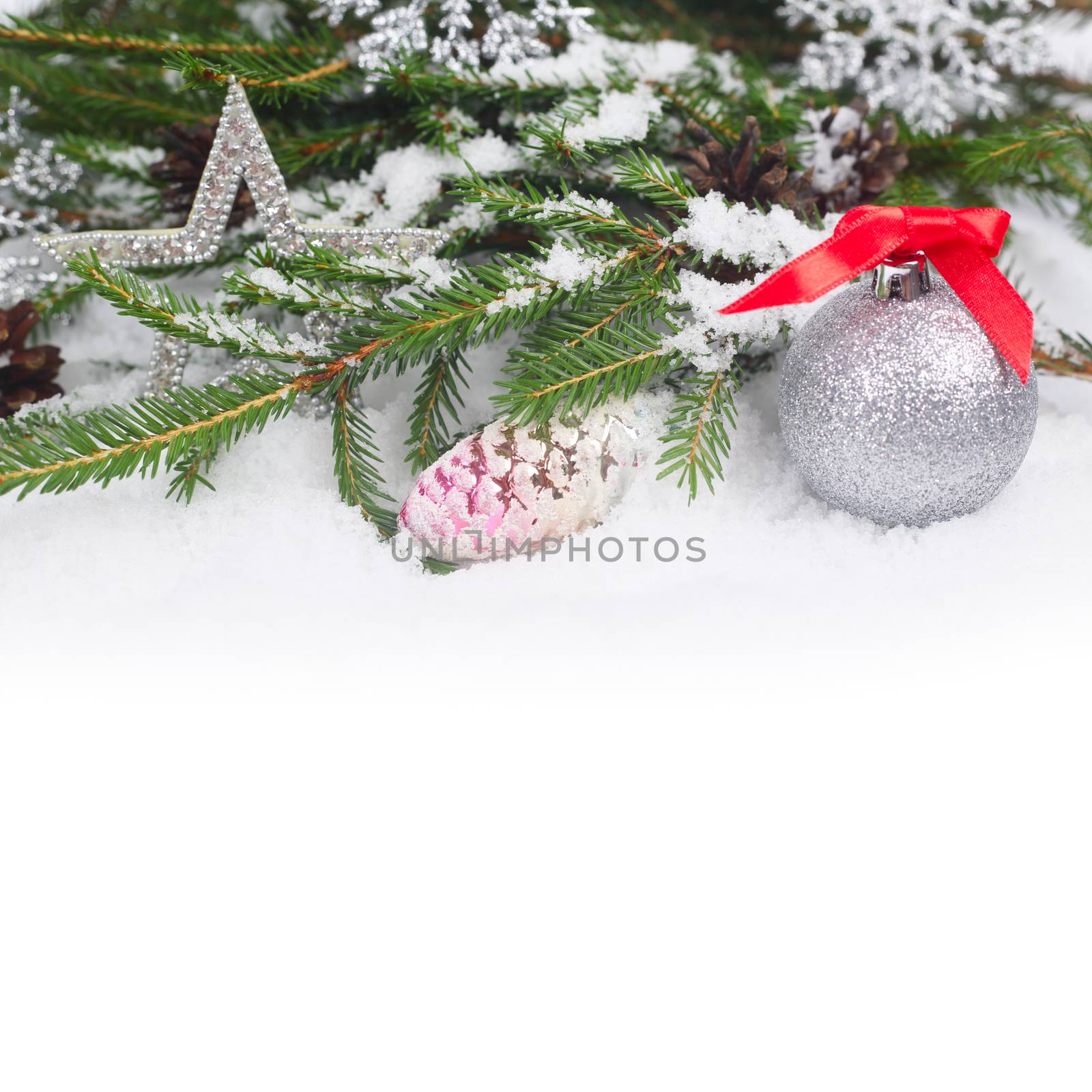 Christmas decorations and fir with pine cones on snow
