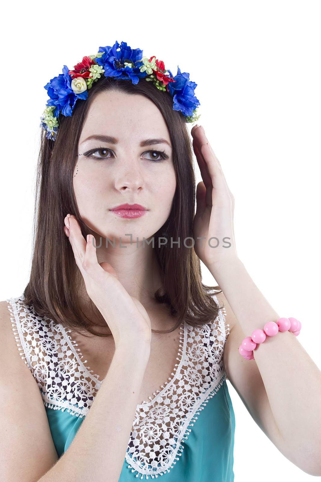 Portrait of a girl in a wreath of flowers on a white background