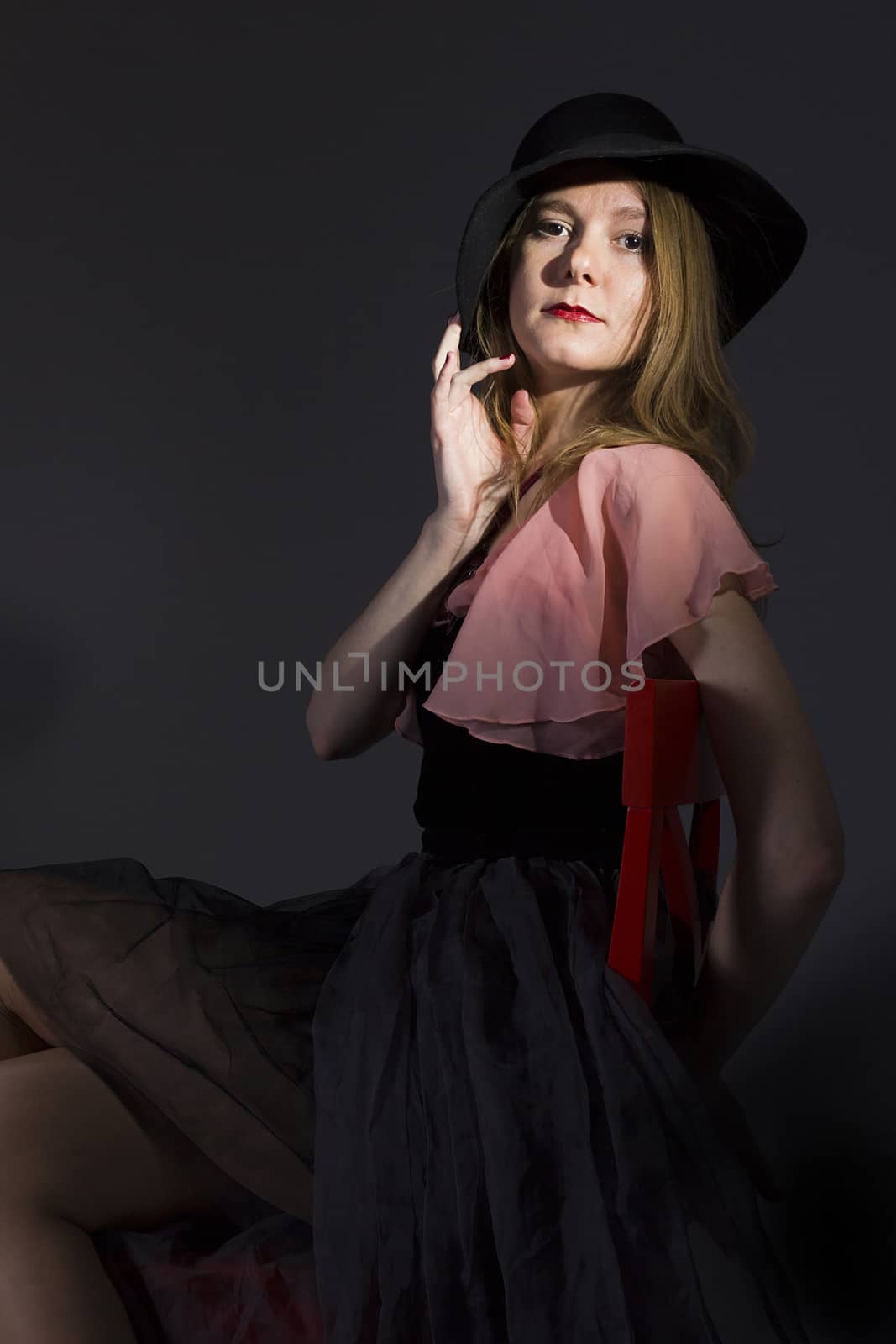 Portrait of a young woman in a hat on a black background