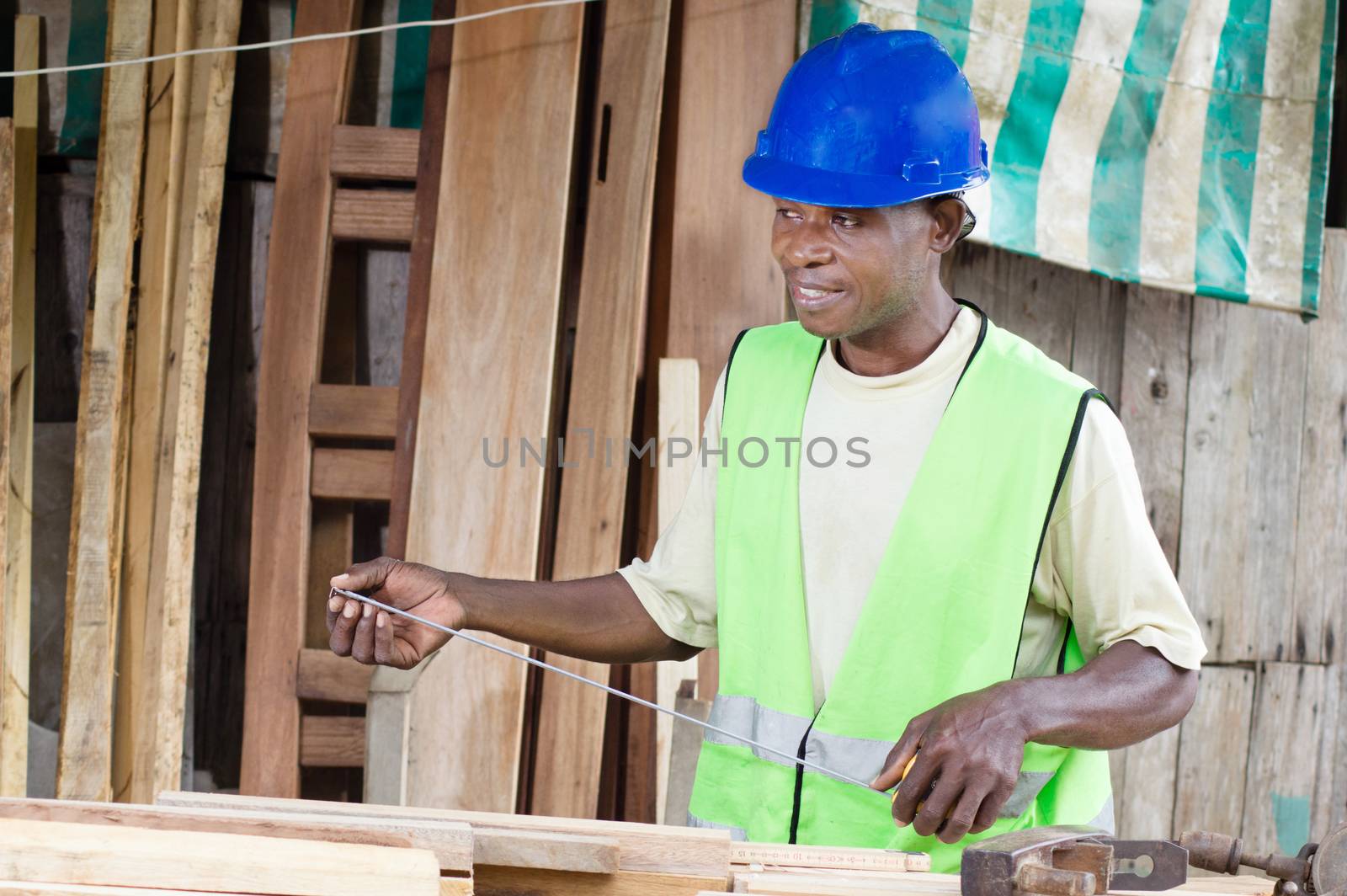 The plane on his desk, the carpenter holds in his hands measurement tool to measure his boarbs