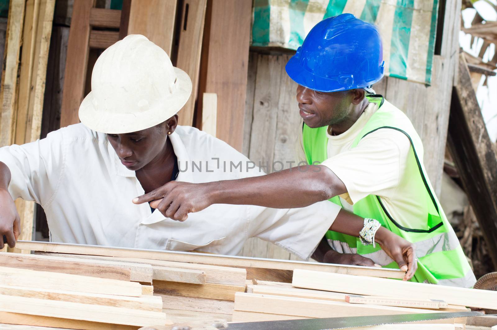 The teacher teaches the student how to measure the boards to have well made furniture