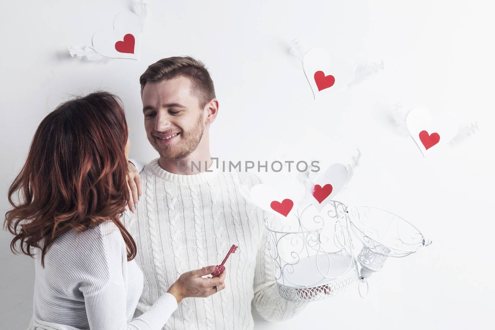 Young couple with winged hearts flying from the cage, Valentines day concept