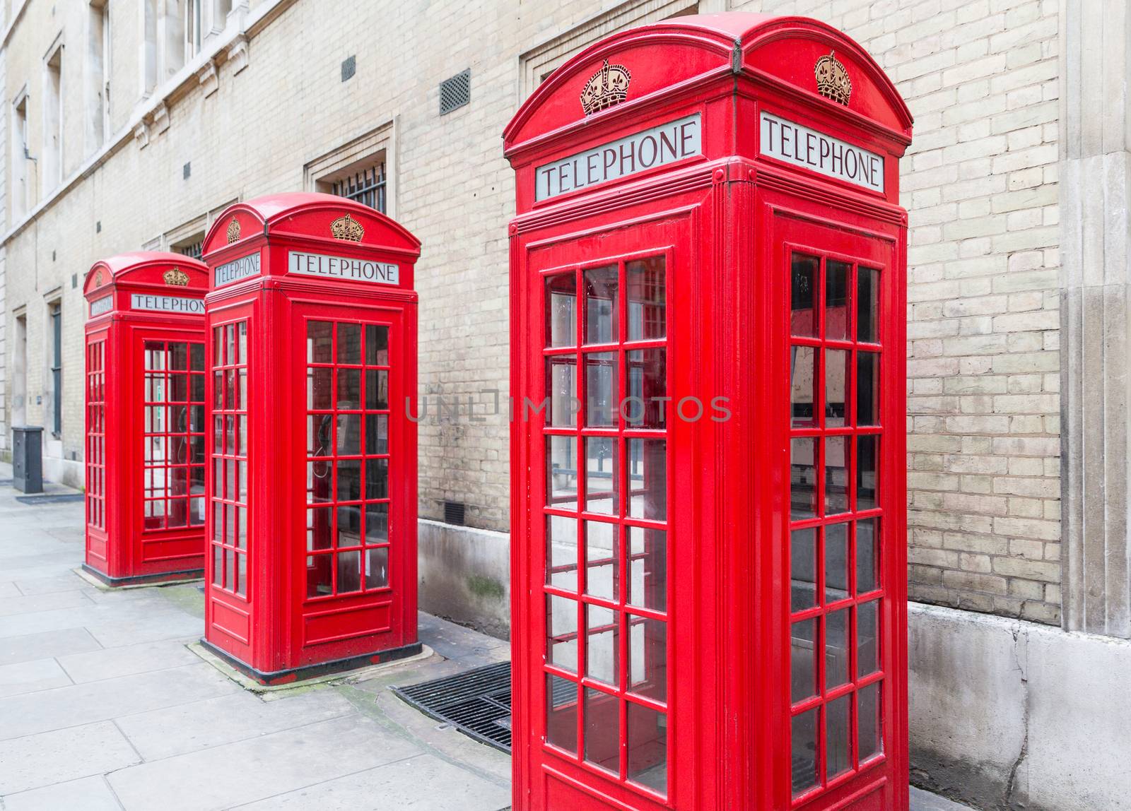 Threee Red London Telephone boxes all in a row in the City
