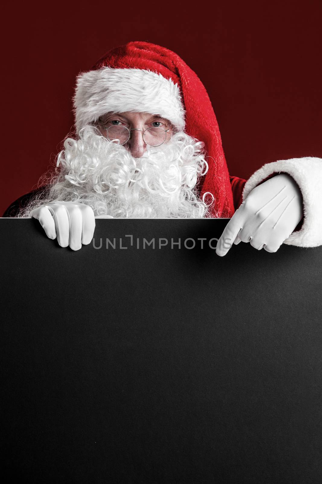 Santa Claus holding big blank paper card with copy space