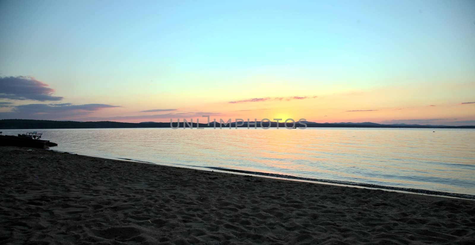 Blurred silhouette, the shore of lake over sunset in background. Beautiful landscape. sunset Image selective focus at lake.