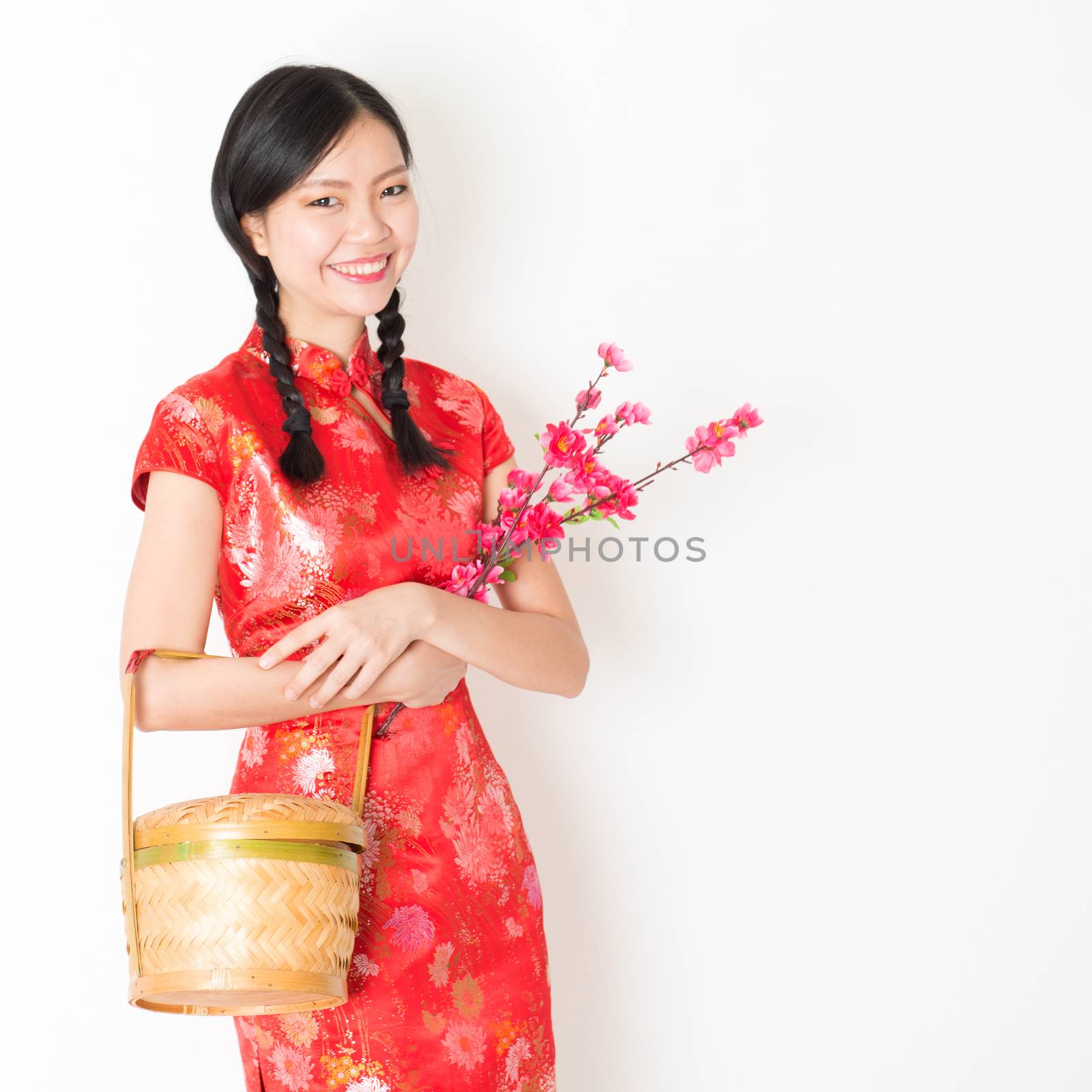 Oriental woman in red cheongsam holding gift basket by szefei
