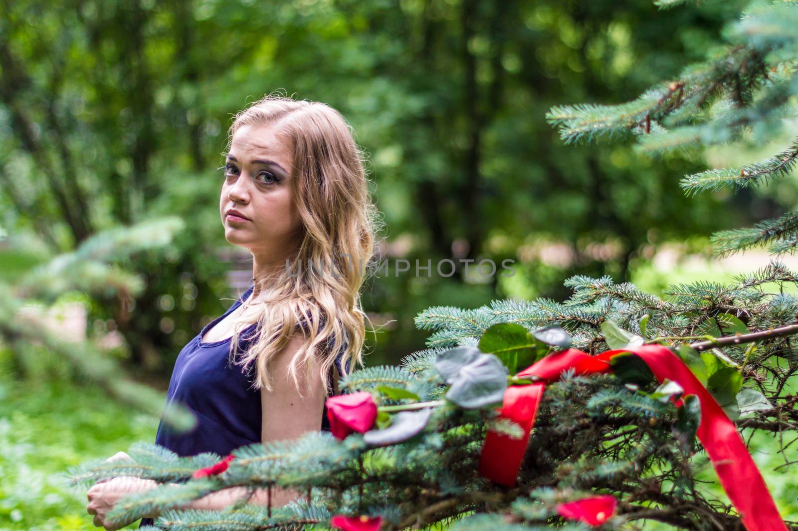 beautiful girl with rose and red tape in the park