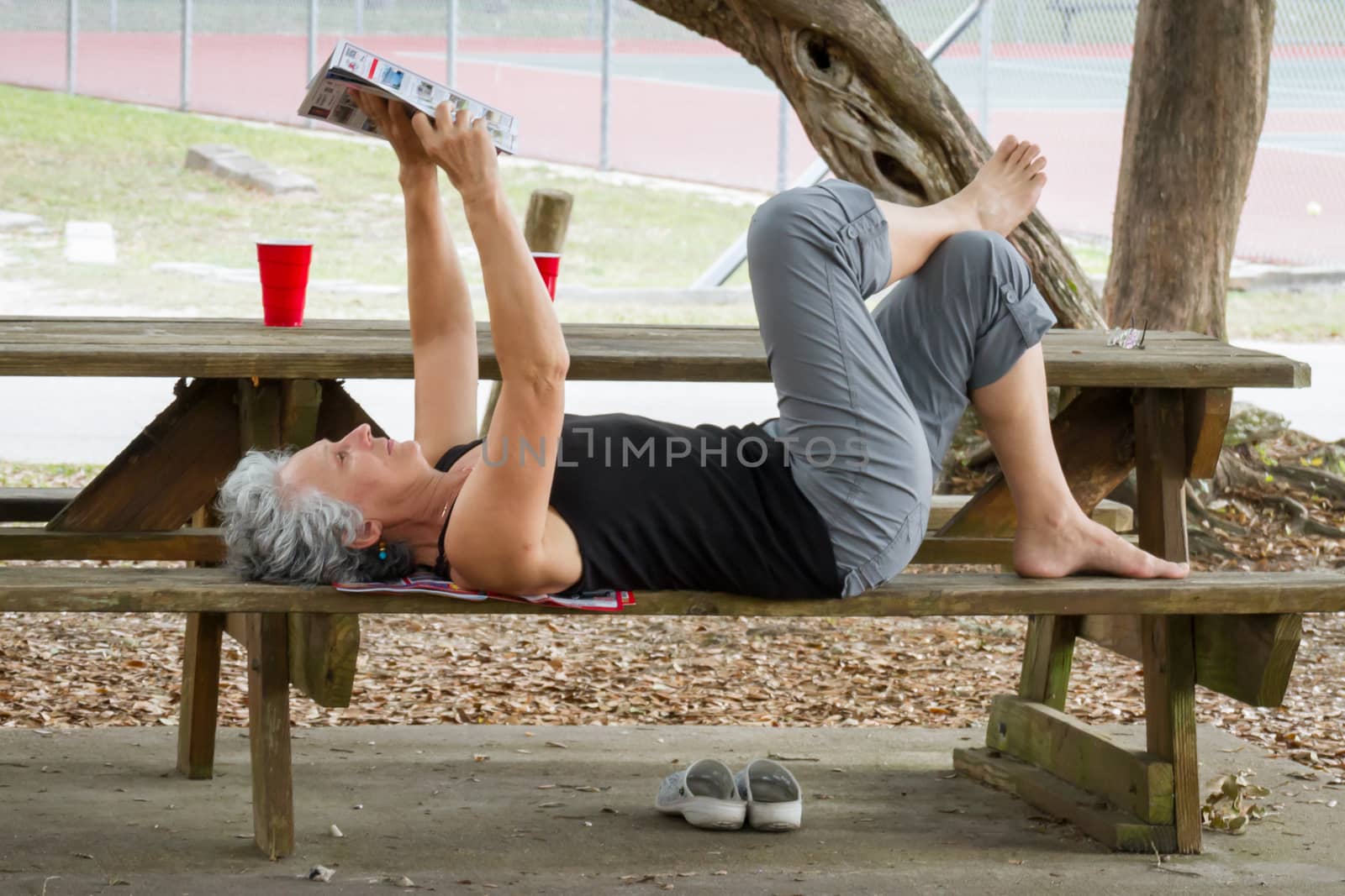 A woman reading a flyer on a picnic table