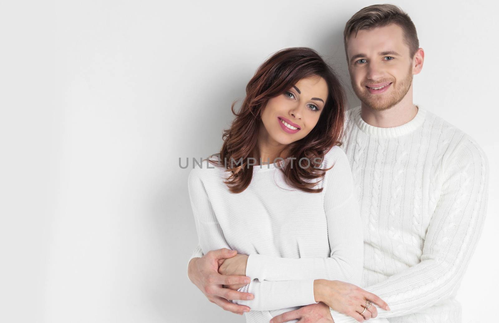 Portrait of young smiling couple in white