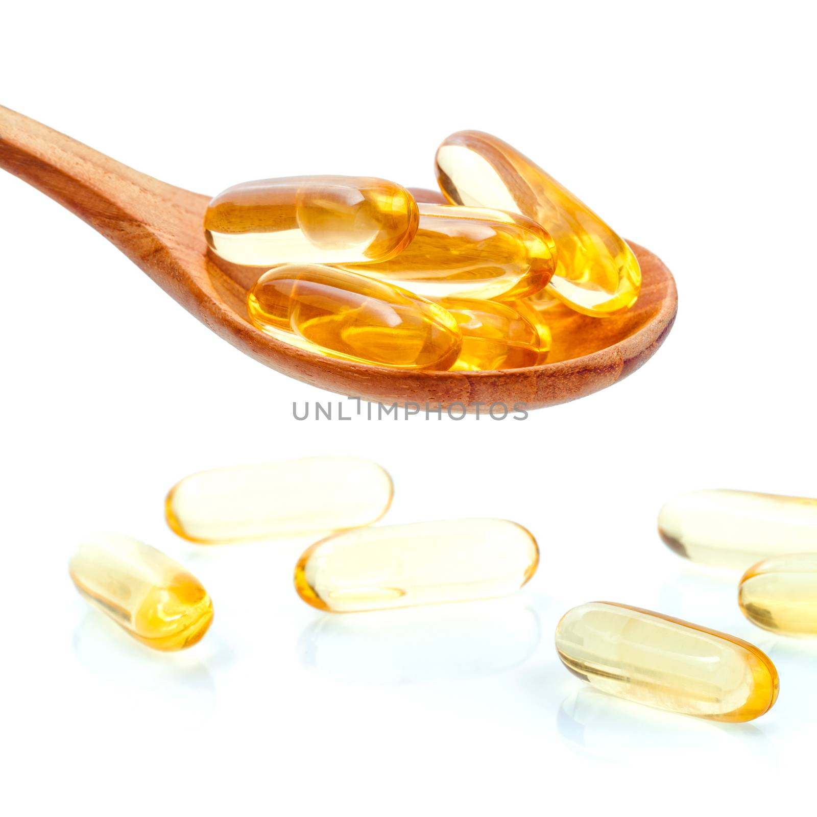 Spoonful of gel capsules of omega 3. Close up capsules fish oil in wooden spoon .The supplement high vitamin E, omega 3 and DHA . Capsules fish oil with selective focus isolate on white background
