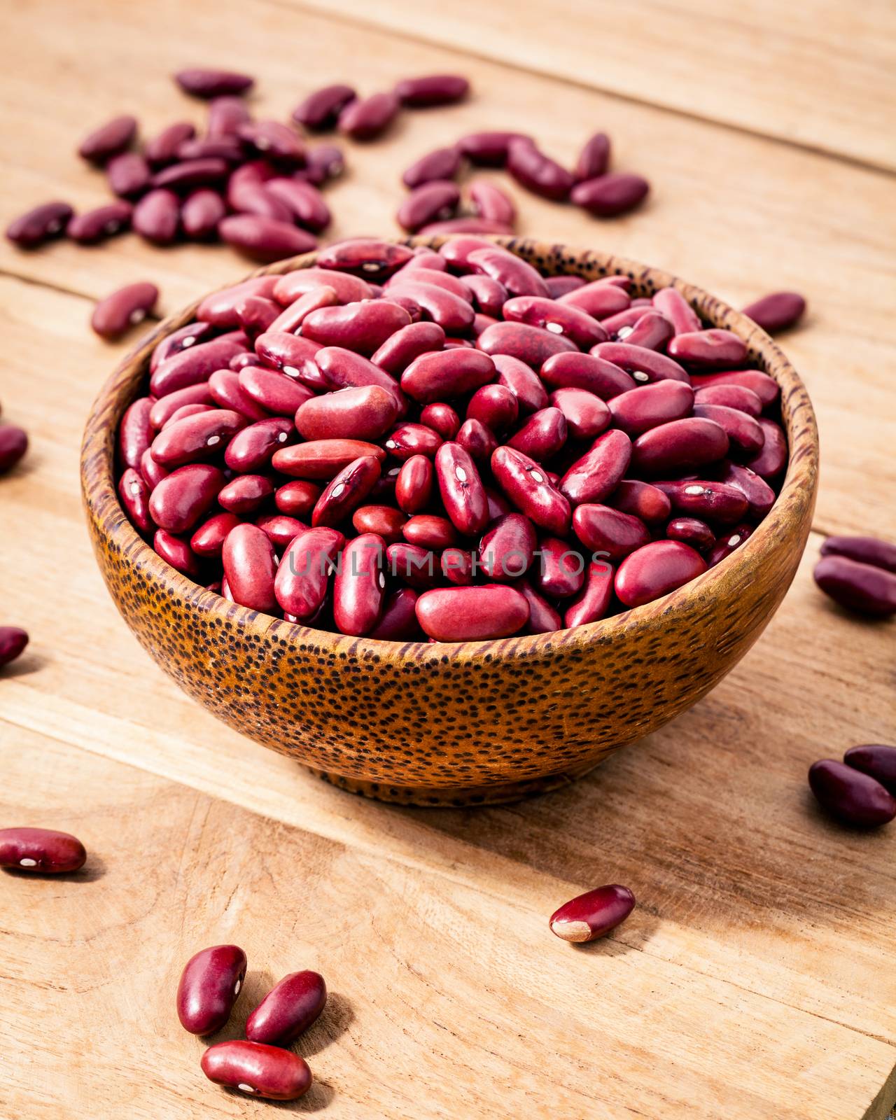 Close up red kidney beans in wooden bowl on wooden background. Selective focus depth of field.