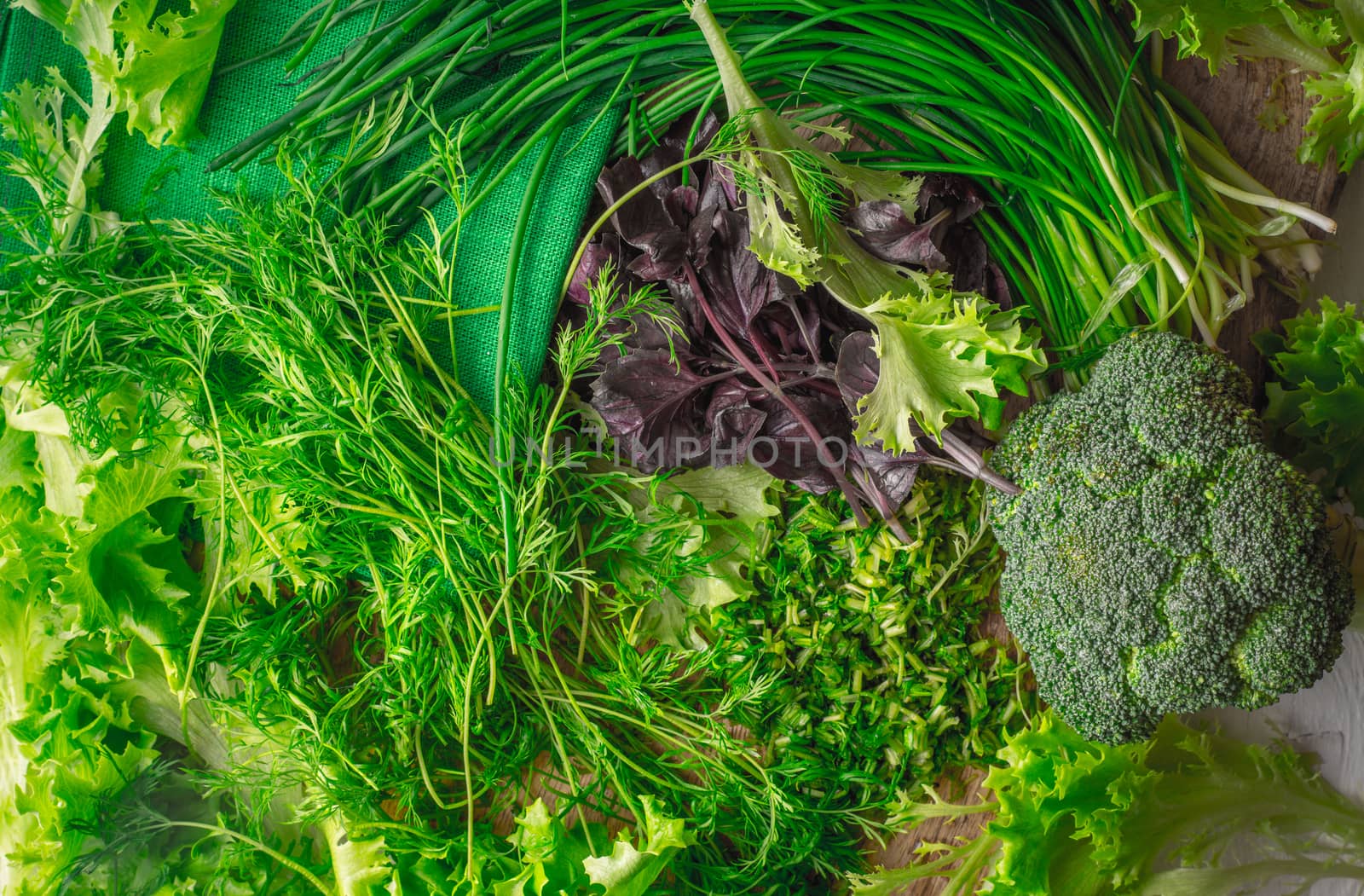 Village salad, broccoli, basil, onion, dill on cutting board by Deniskarpenkov