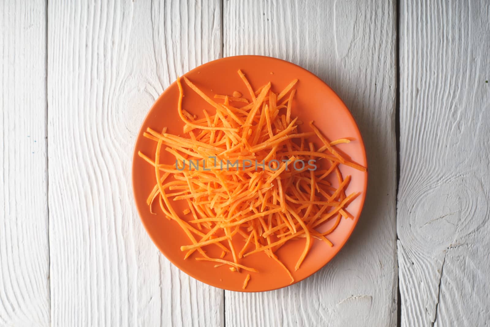 Fresh grated carrot on a plate by Deniskarpenkov