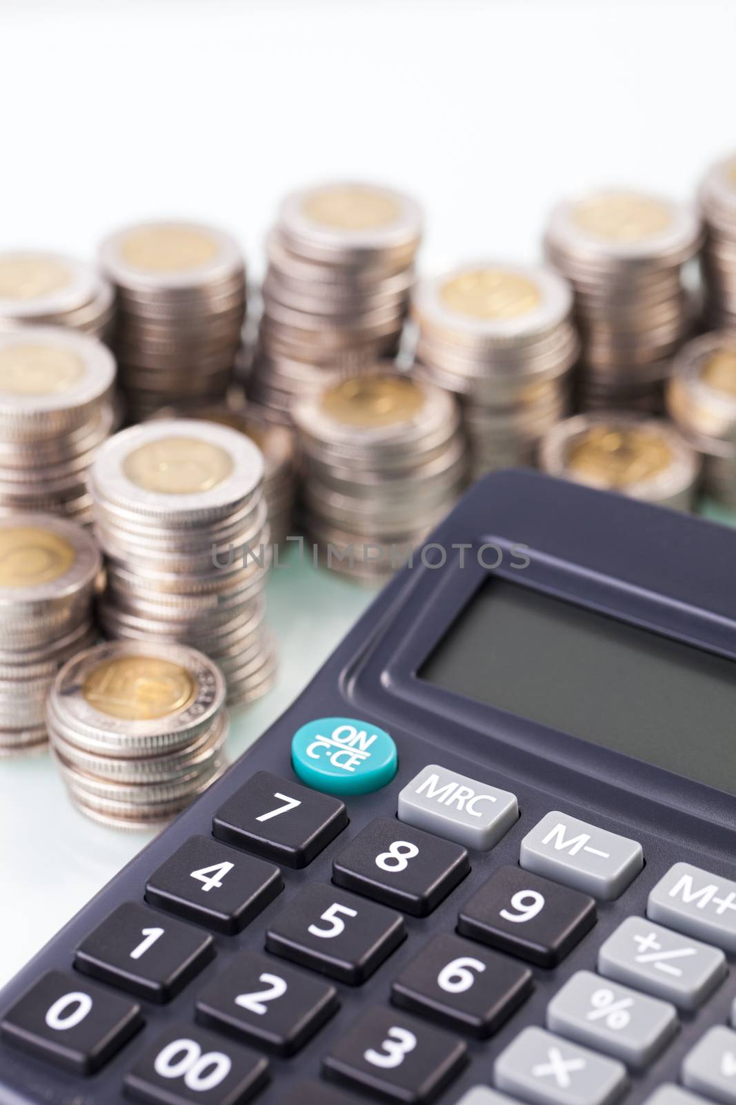 counting income, pile of money, calculator in white background