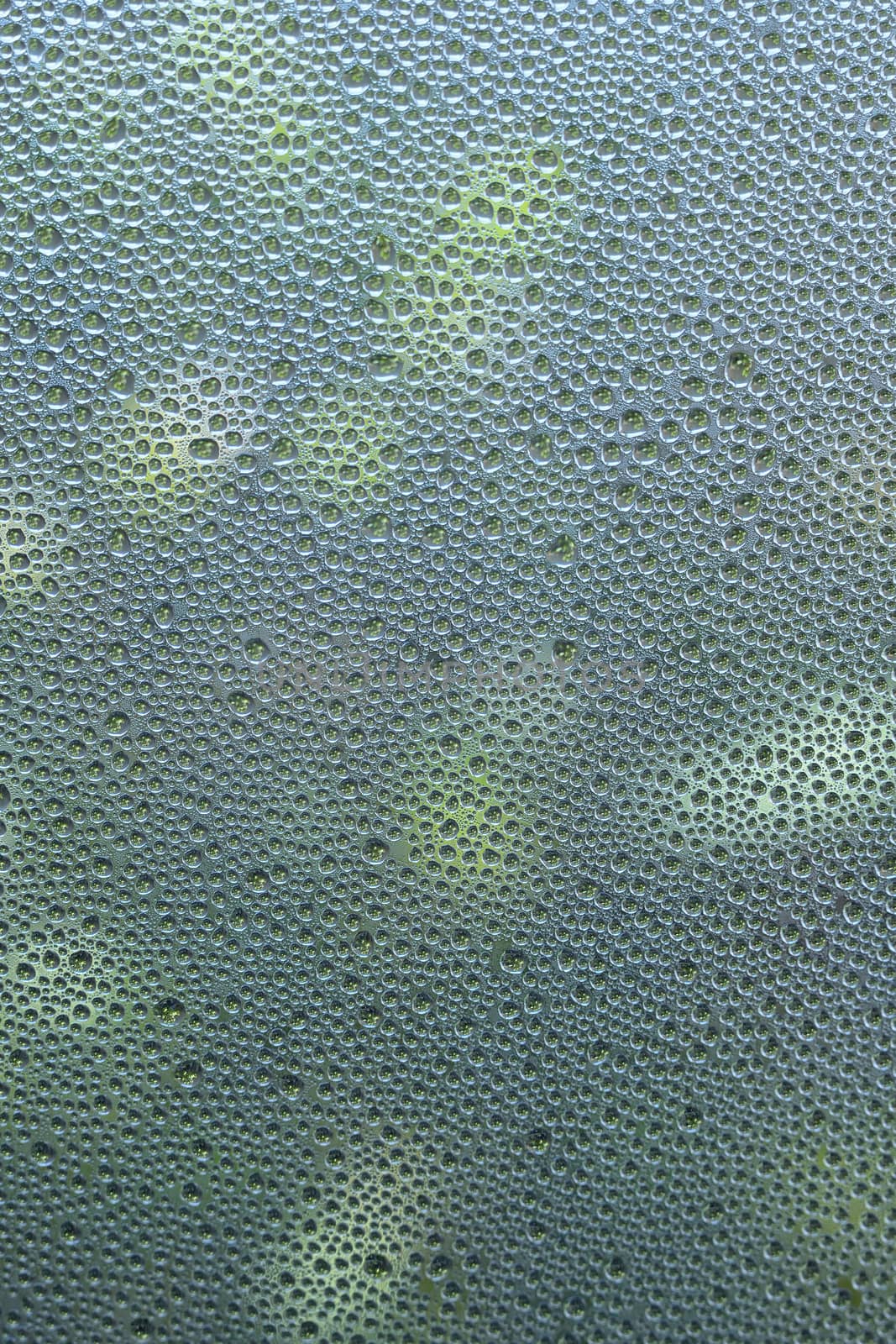 Macro texture water dews on clear glass surface in vertical frame