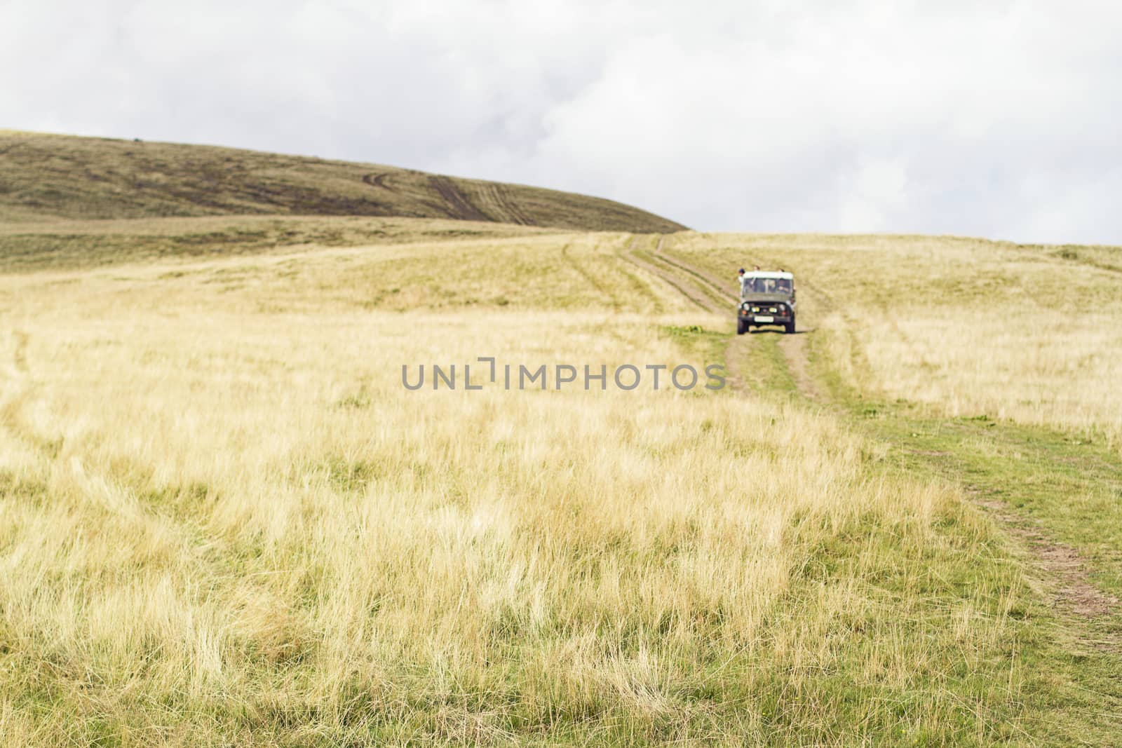 Wide panoramic scenic view at high meadow, mountain valley dry yellow grass, autumn, emptiness,  car in the distance