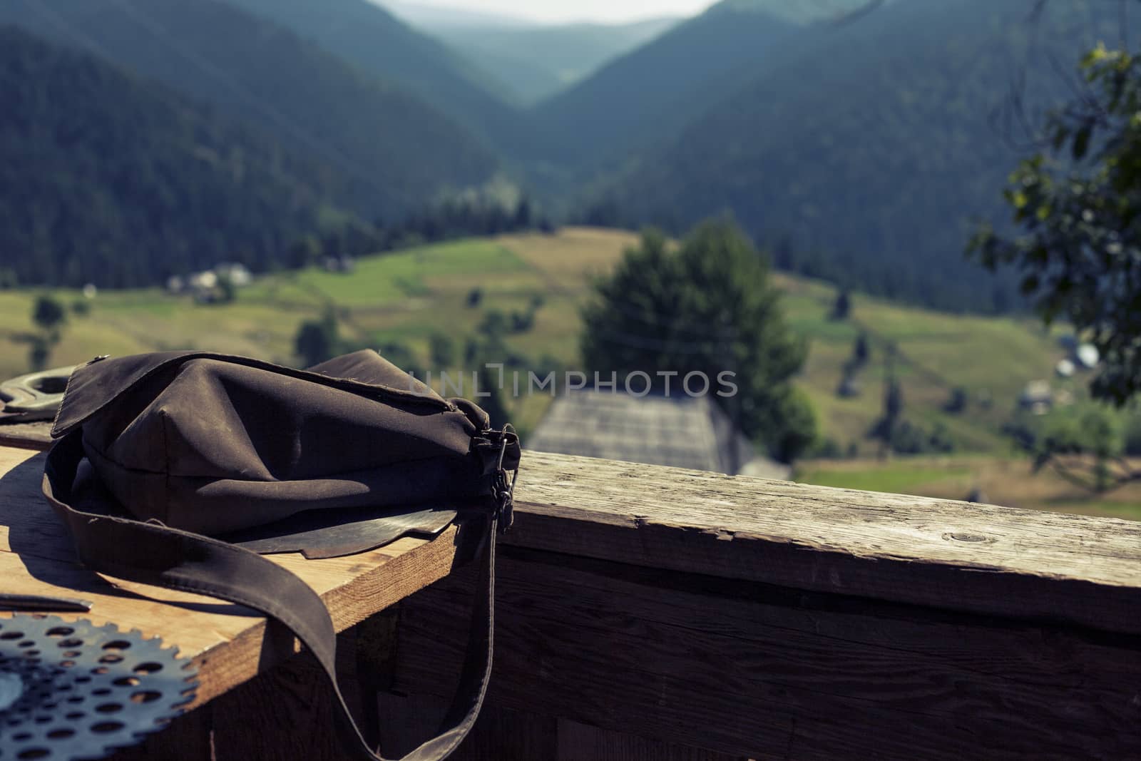 Small settlement rural nature in mountain. View from balcony. Bag on foreground Houses, outbuildings and fields.