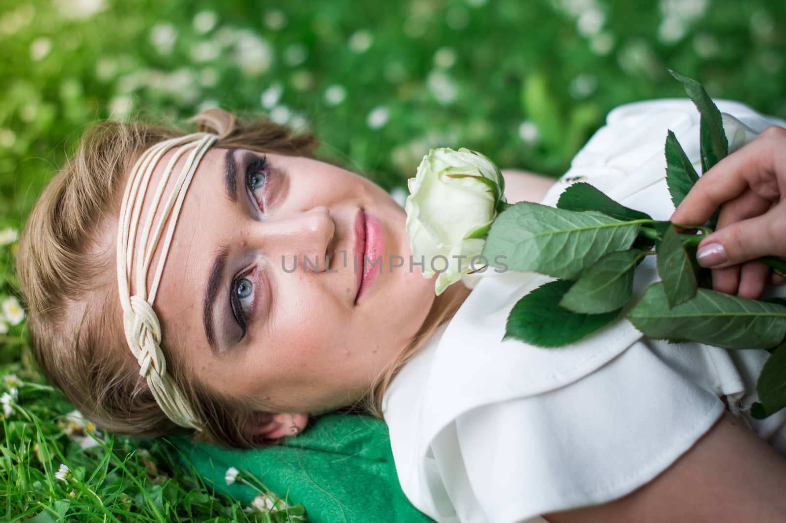 beautiful girl with a white rose in the Park on the grass