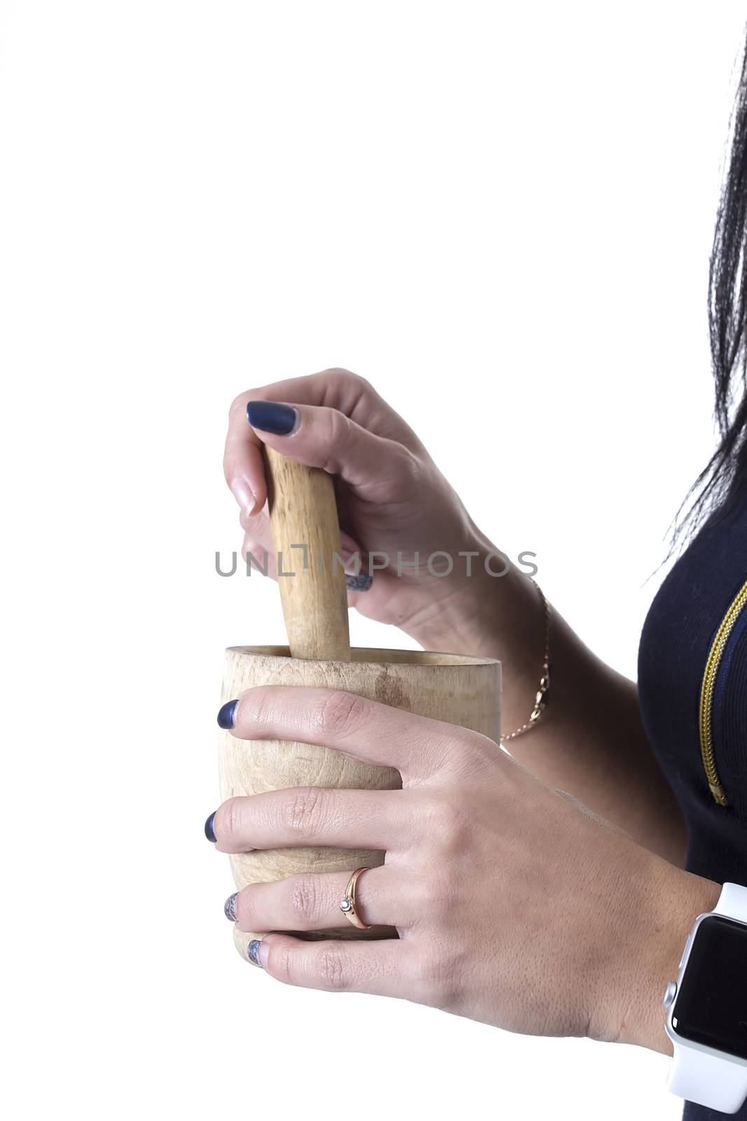 Wooden mortar in female hands on a white background