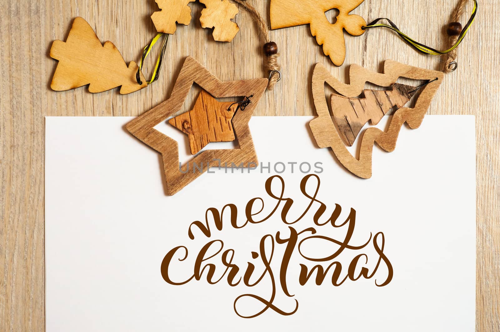 Wooden toys on white background with text Merry Christmas. Calligraphy lettering.
